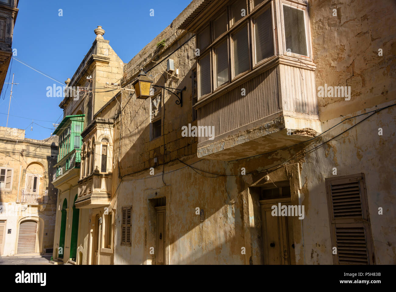 Un balcon en bois sur des maisons traditionnelles dans les ruelles de la vieille ville de Victoria, Gozo, Malte. Banque D'Images