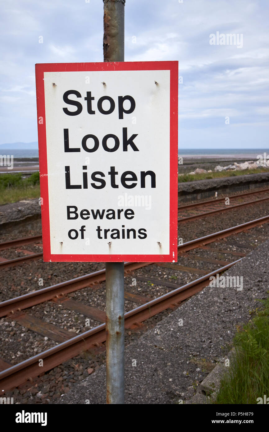 Arrêter de regarder écouter panneau d'avertissement au passage à niveau piétonnier sans pilote sur la voie côtière Cumbria England UK Banque D'Images