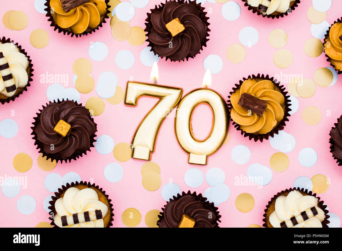 Nombre d'or avec 70 bougies cupcakes contre un fond rose pastel Banque D'Images