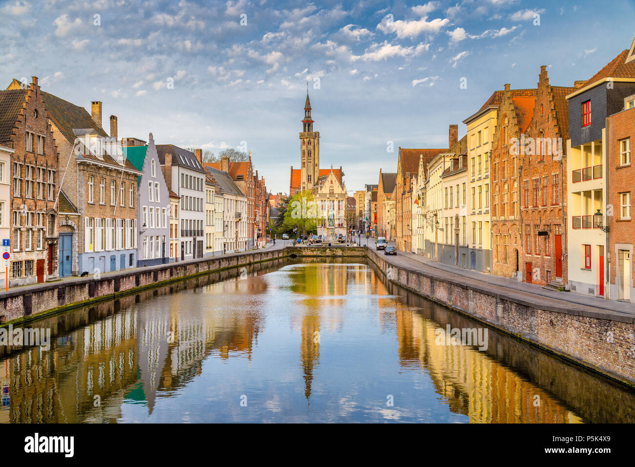 Ville historique de Bruges, avec célèbre canal Spiegelrei, Poortersloge et Jan van Eyck square à l'arrière-plan éclairé par golden matin, Belgique Banque D'Images