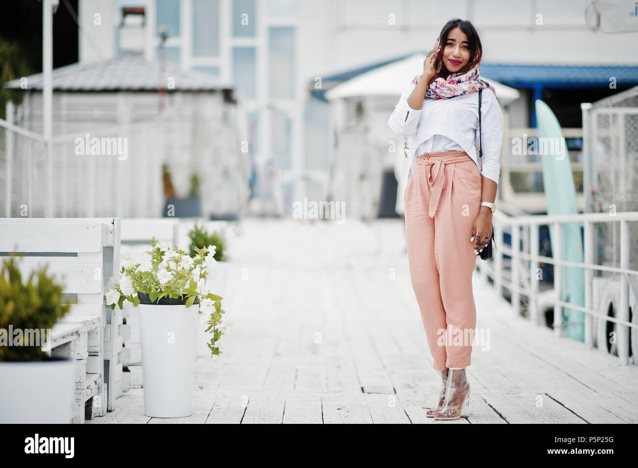 Fashion girl arabe à blouse blanche et pêche pantalon posés à l'extérieur.  Élégant femme musulmane Photo Stock - Alamy