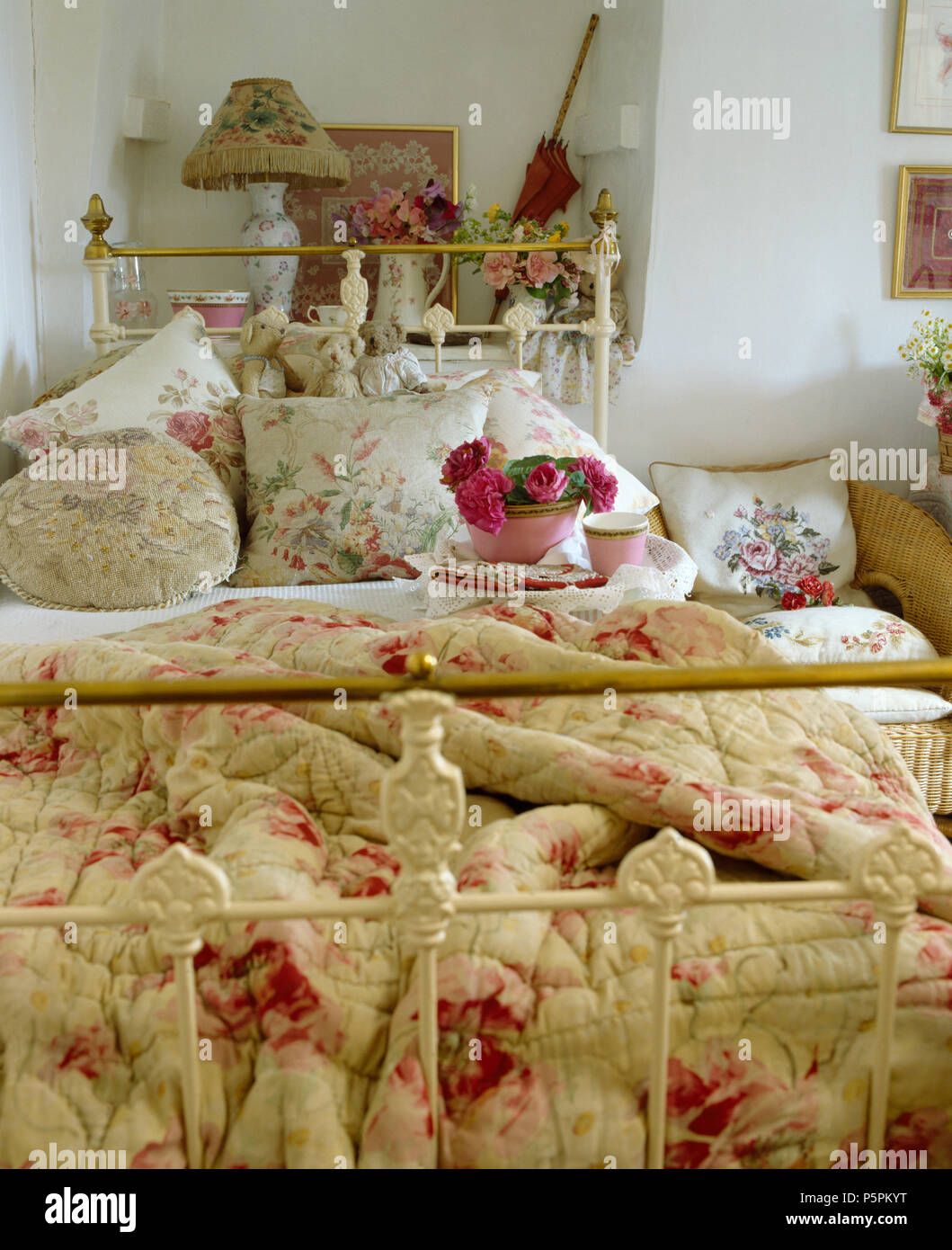 Courtepointe à motifs de roses et de fleurs coussins sur laiton vintage lit  simple en chambre cottage Photo Stock - Alamy