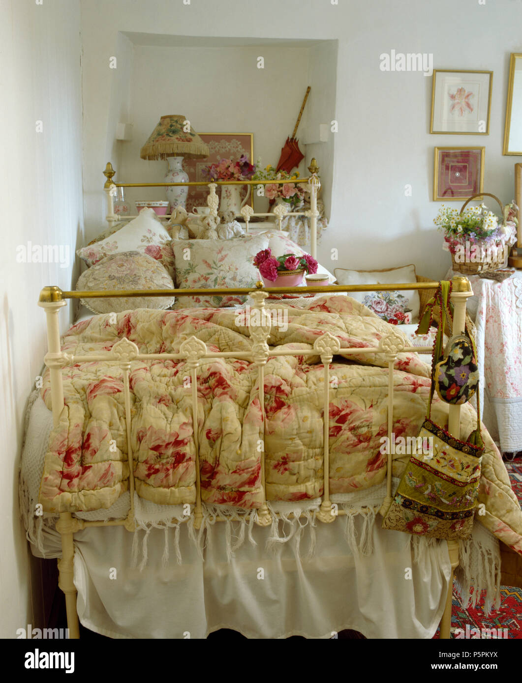 Courtepointe à motifs de roses sur blanc laiton vintage lit simple en chambre cottage Banque D'Images