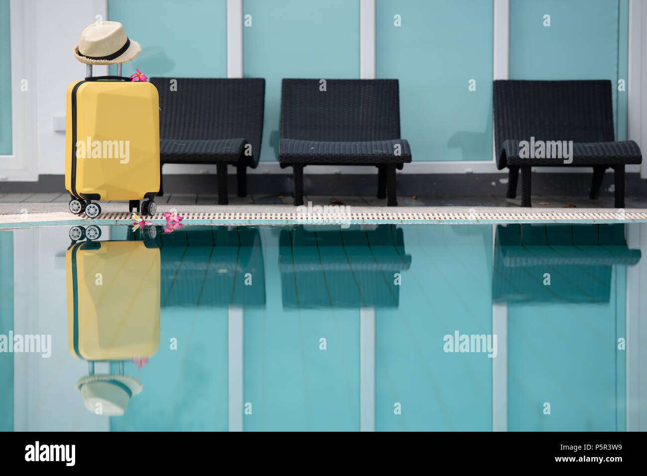 Valise, bagage, bagage avec chapeau près de la piscine et chaise de natation, détente, vacances, concept de temps de voyage. Banque D'Images