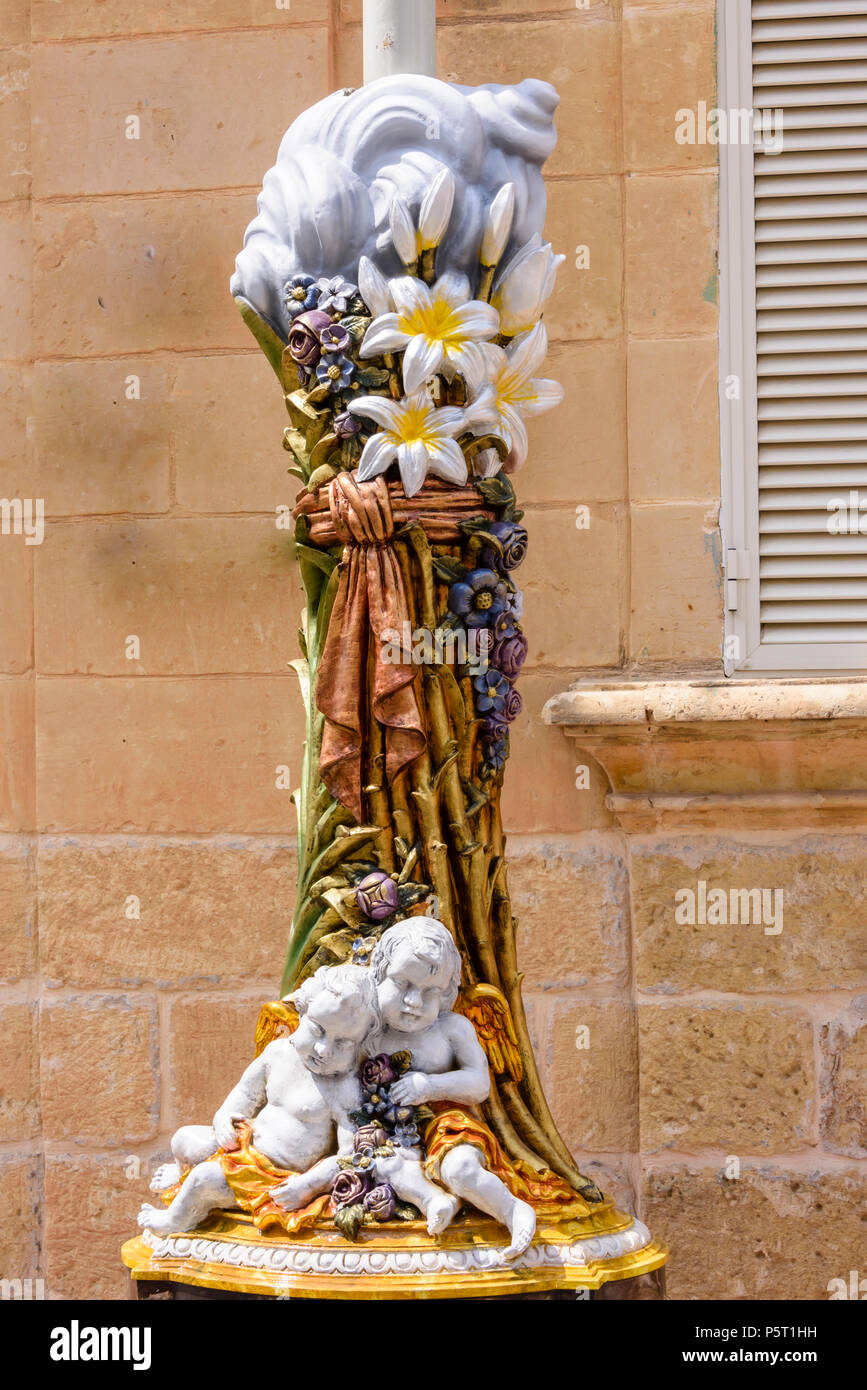 Une décoration en fibre est attaché à un réverbère à l'avance d'une cérémonie religieuse dans Nadur, Gozo, Malte Banque D'Images