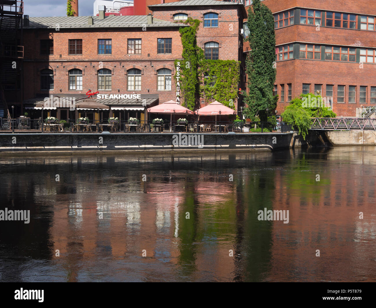 Old Red Brick architecture industrielle le long de la rivière Tammerkoski à Tampere en Finlande a prix d'un restaurant avec coin salon extérieur Banque D'Images