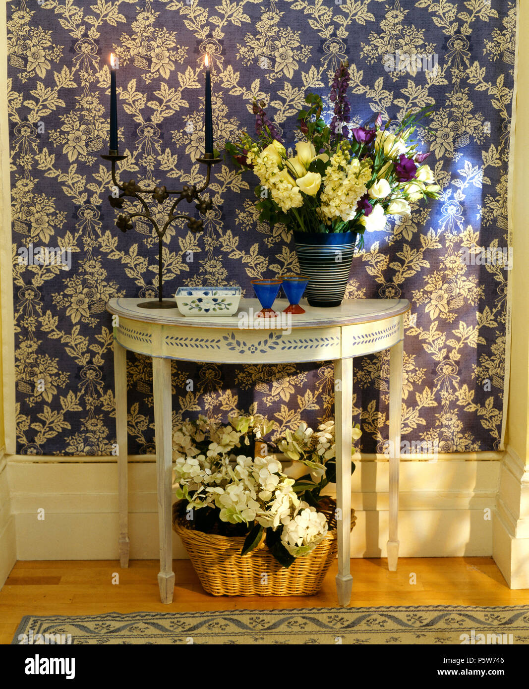 Papier peint blanc +bleu dans le hall avec vase de fleurs de printemps sur peint Table console avec design stencil Banque D'Images