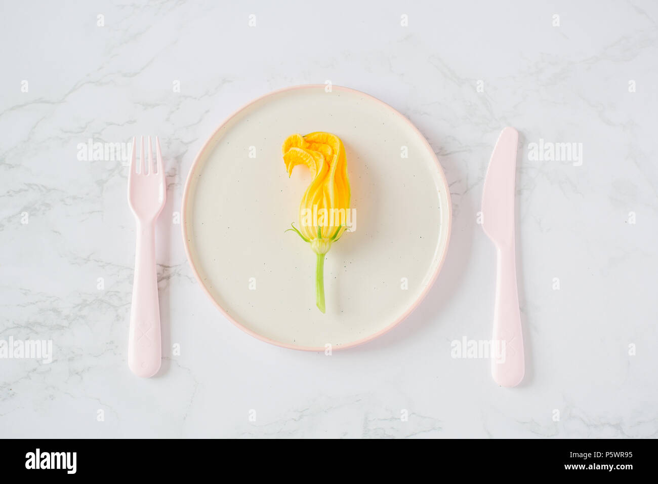 Fleurs de courgettes dans une assiette sur un fond clair Banque D'Images