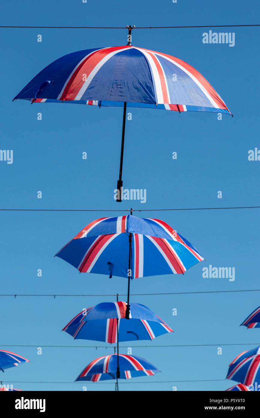 Suspendus parapluies British Flag contre un ciel bleu clair Banque D'Images