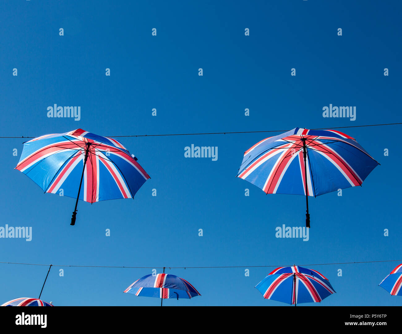 Suspendus parapluies British Flag contre un ciel bleu clair Banque D'Images
