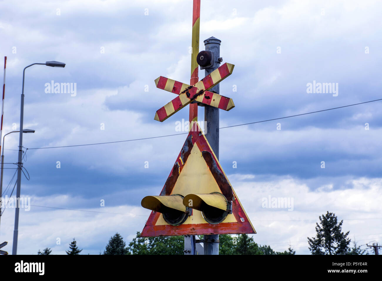 Old Railroad crossing sign lights et triangle en Serbie, l'Europe et dramatique ciel nuageux. Close up, selective focus Banque D'Images