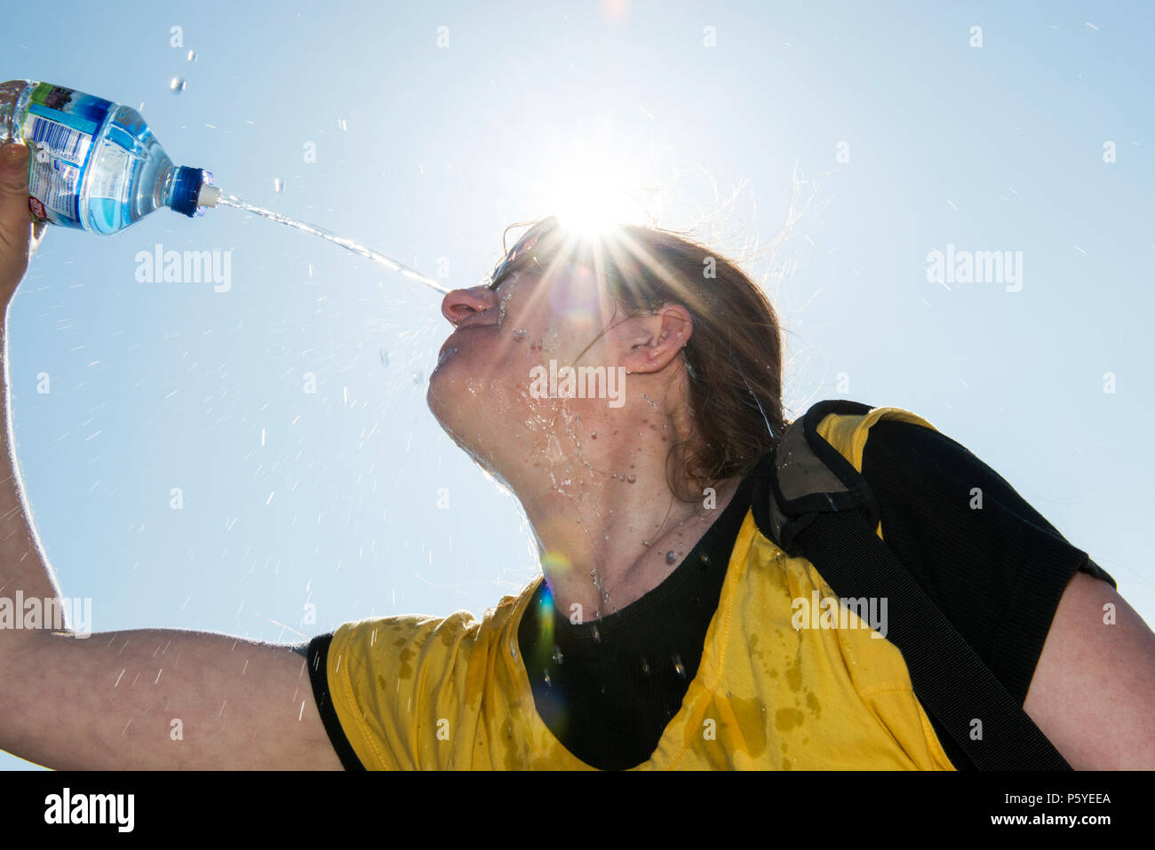 Parution modèle femme bénéficiant d'une bouteille d'eau de source sur une journée chaude. Banque D'Images