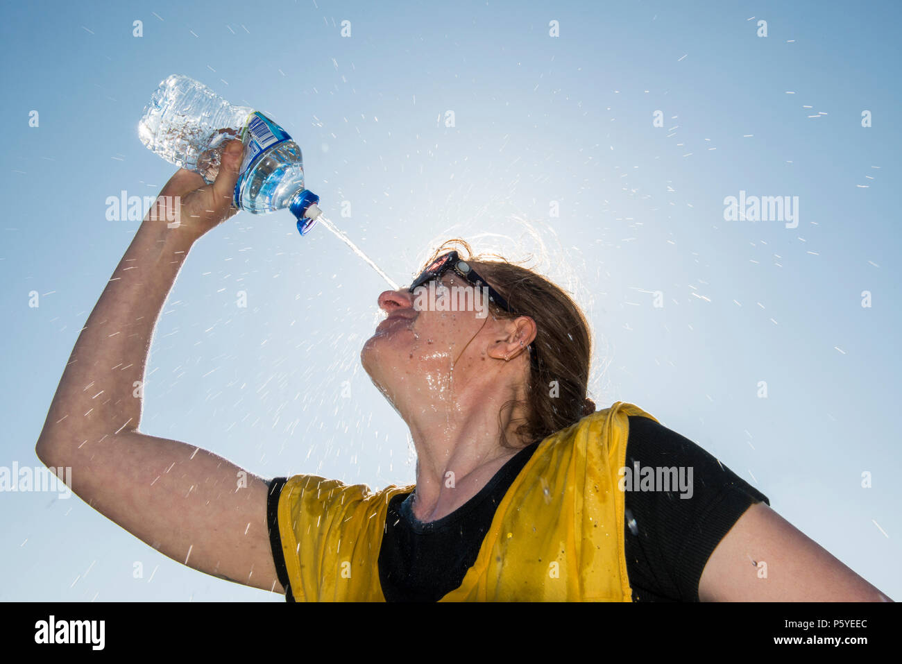 Parution modèle femme bénéficiant d'une bouteille d'eau de source sur une journée chaude. Banque D'Images