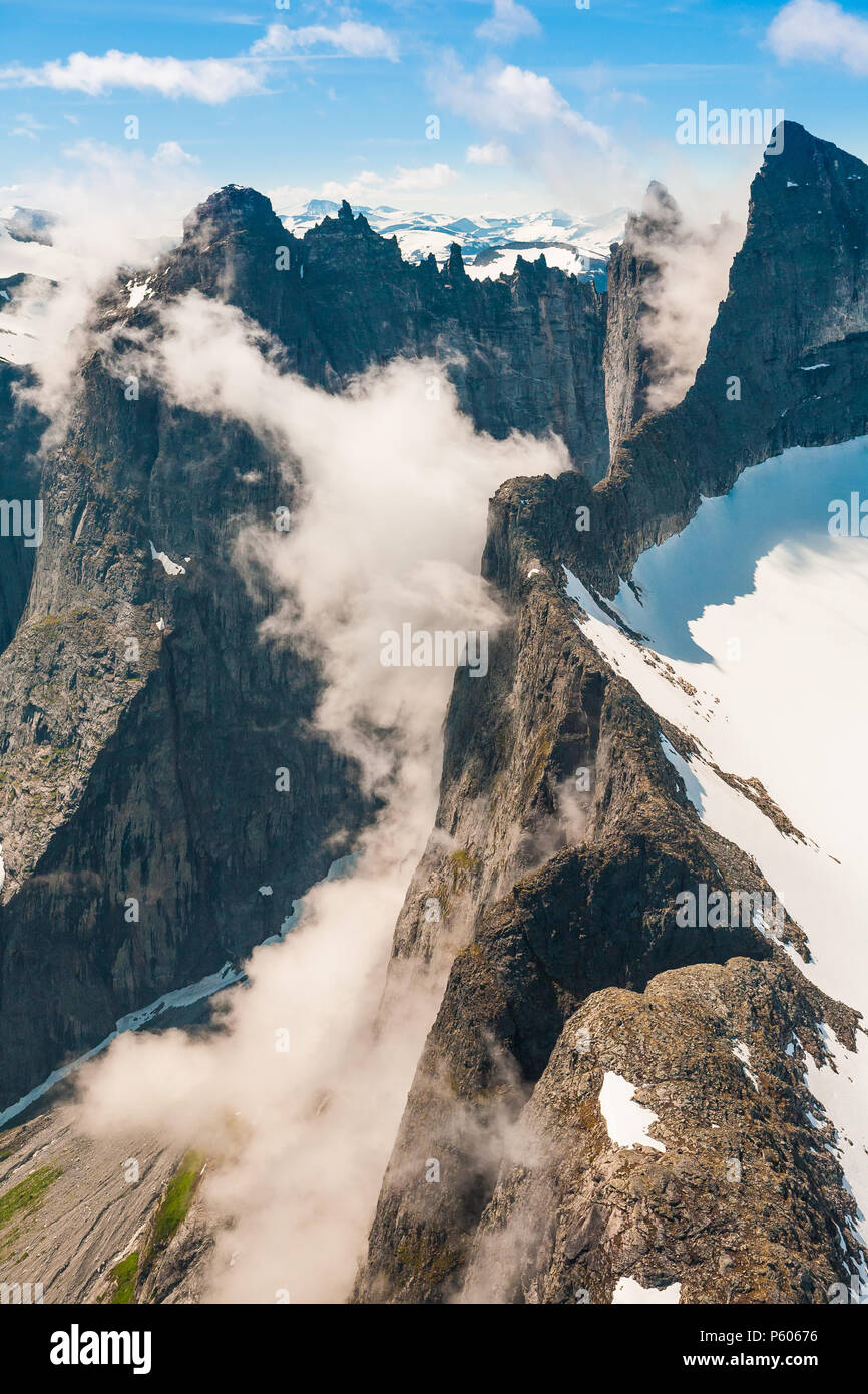 Vue aérienne des montagnes dans la vallée de Romsdalen, Møre og Romsdal (Norvège). Les 3000 pieds sur le plan vertical mur Troll est partiellement couvert par le brouillard. Banque D'Images
