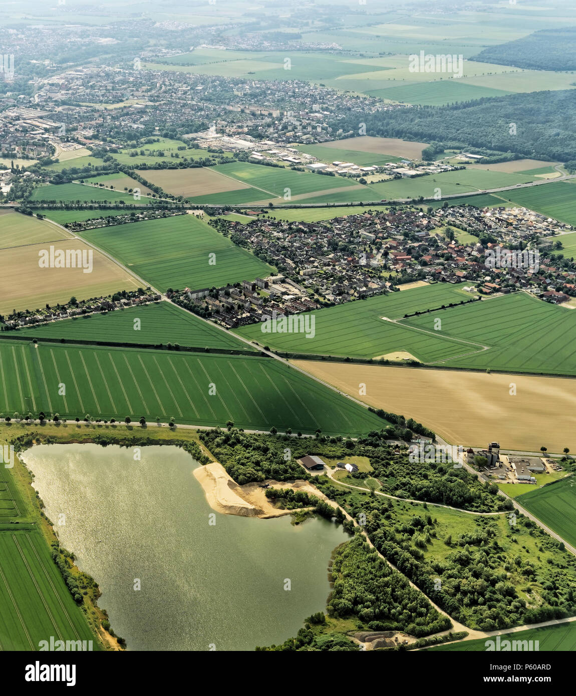 Banlieue de Braunschweig, Allemagne avec un plateau rempli d'eau ancienne gravière au premier plan, la structure du village avec des champs et prairies, photo aérienne, ligh Banque D'Images