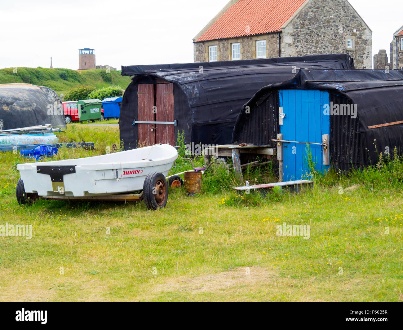 Vieux bateaux renversés converti en cabanes de pêcheurs par le port sur Holy Island au large de la côte de Northumberland en Angleterre du Nord-Est Banque D'Images
