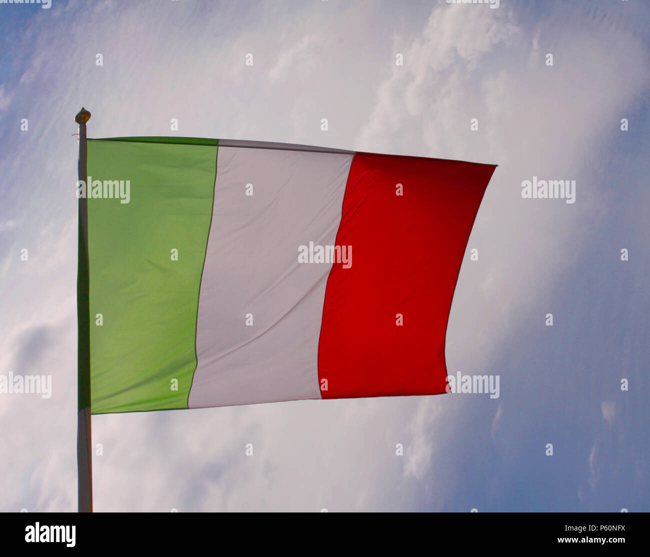 Brandir le drapeau mexicain dans le vent sur un poteau avec fond de ciel bleu rétroéclairé Banque D'Images