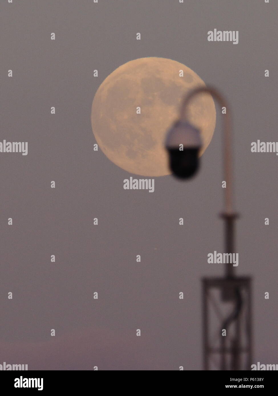 Queenborough, Kent, UK. 27 Juin, 2018. Météo France : la fraise pleine lune se lève derrière une caméra de sécurité dans la ville de Queenborough, dans le Kent. Credit : James Bell/Alamy Live News Banque D'Images