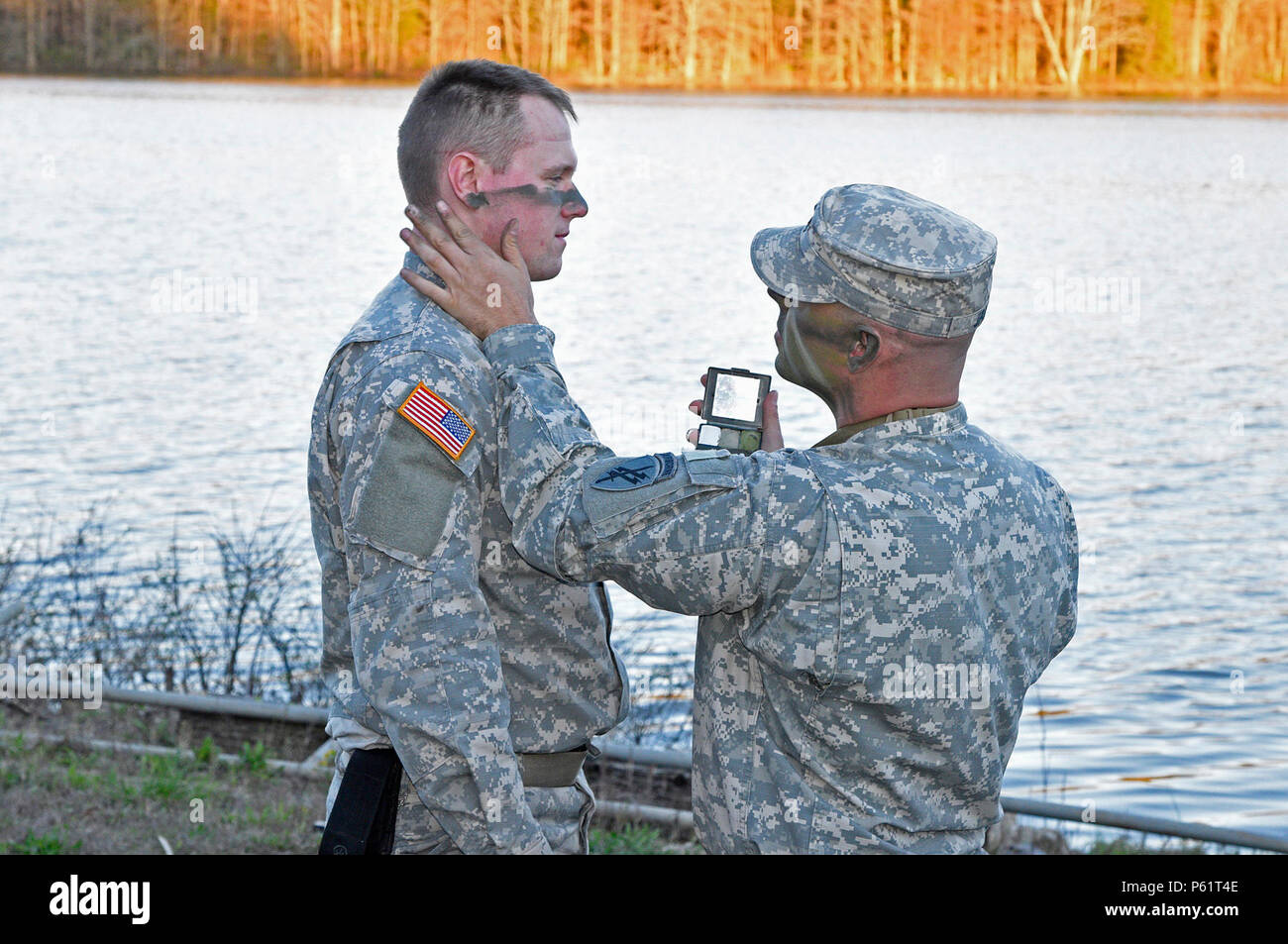 Le s.. Larry James applique domaine camouflage pour 1er lieutenant Benton Harvey à la Garde nationale de l'Indiana Muscatatuck Urban Training Centre comme leur unité, la réserve de l'armée d'opérations psychologiques du 346e Airborne (Entreprise) de Columbus, Ohio, dispense une formation le mercredi 13 avril. La Garde nationale de l'Indiana (photo par le Sgt. Brad Staggs, Atterbury-Muscatatuck Affaires publiques) Banque D'Images