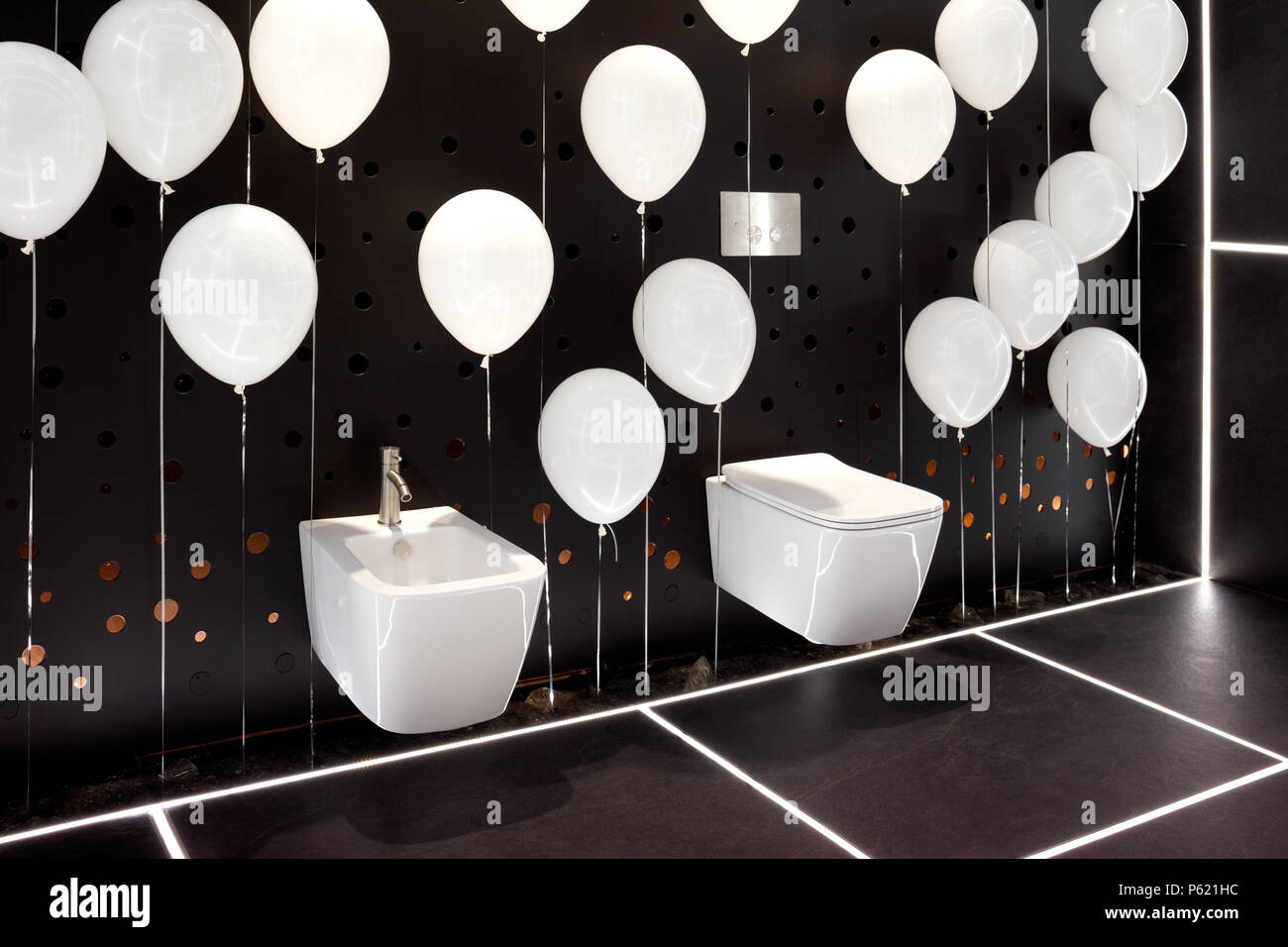Pendentif moderne blanc de la cuvette des toilettes et bidet dans l'intérieur de salle de bains noir blanc avec des ballons gonflables Banque D'Images