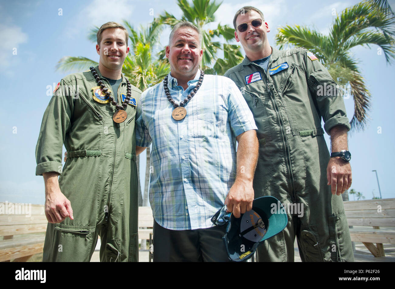 Jonathon Hoag, centre, pêcheur commercial et de recherche et sauvetage (SAR) survivant, pose pour une photo de groupe avec l'hélicoptère de la Marine américaine Aircrewman-Tactical 2e classe Ryan Hodges, gauche, Hélicoptère Escadron grève maritime trente-sept, et le lieutenant de la US Coast Guard Air Station Michael Koehler, barbiers, point H65 HC-130 Boîtier d'air, devoir l'article C-130, pilote le 1 avril 2016, à la station de l'air Point, New York. barbiers Hodges et Koehler avait deux personnes qui faisaient partie d'un effort de R-d'extraire et son Hoag deux membres d'équipage à la sécurité après le chavirement de leur bateau 161 milles au sud-ouest de Kona, Hawaii le 11 mars Banque D'Images