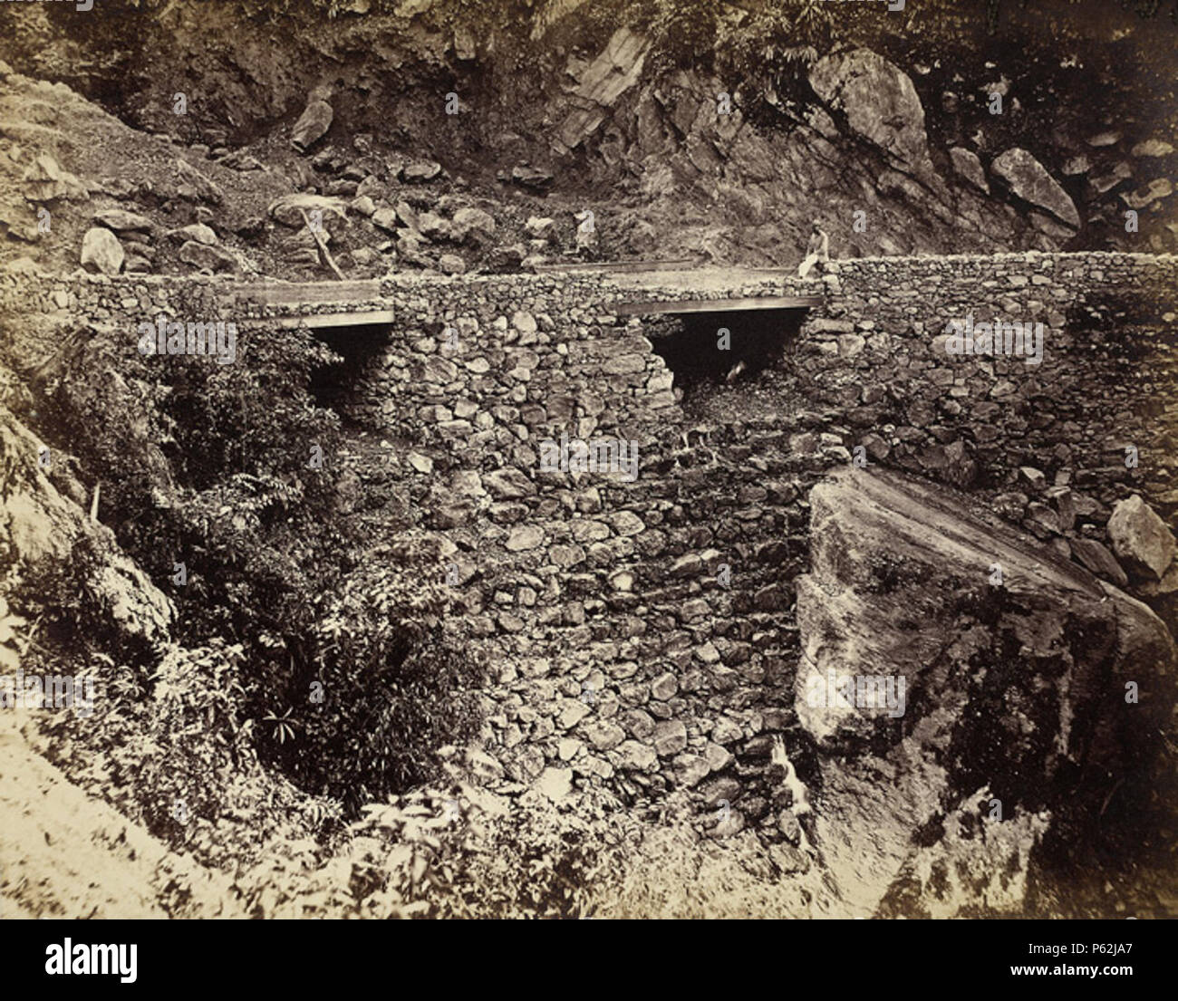 N/A. Anglais : Réparations, à 3 km au-dessus de Kurseong. Photographie de l'album de vues montrant la construction de la Darjeeling Hill Road prise par un photographe inconnu en 1865. La route reliant Siliguri à Darjeeling sur les plaines a été lancé en 1861 en grande partie à cause de l'expansion soudaine des plantations de thé dans les montagnes. Construit et entretenu par le Département des travaux publics, il a été de 48 milles de long, 25 pieds de large et coûte environ £6 000 par mille à construire. Cette route était très difficile à construire : le cimes boisées hills étaient difficiles à effacer, le sol était rocheux et escarpés, Banque D'Images