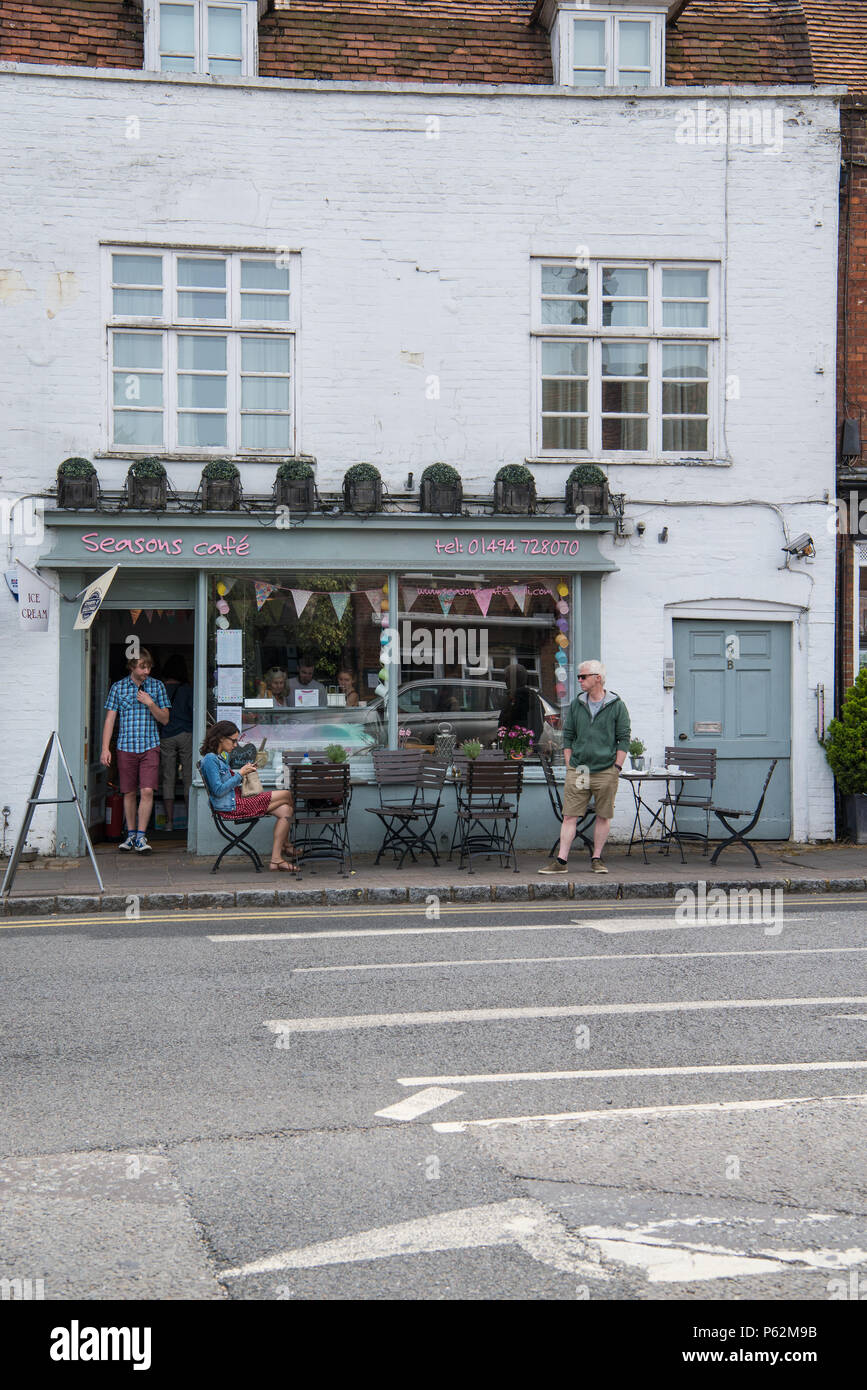 Femme assise à la table de la chaussée et l'homme debout à l'extérieur de Seasons Cafe Deli dans la place du marché, la vieille ville, Amersham Buckinghamshire, Angleterre, Royaume-Uni Banque D'Images