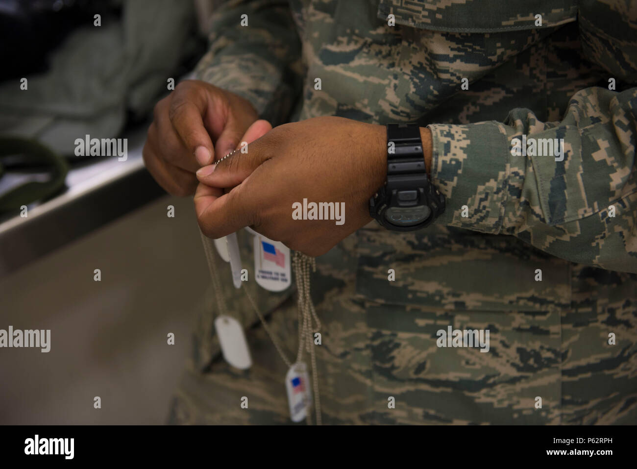 Démêle un aviateur mock dog tags pour les enfants qui fréquentent le Gunfighter Jr. le 4 avril 2016 de l'événement, à Mountain Home Air Force Base, Texas. Ces plaques ont été remis aux enfants participant à l'événement. (U.S. Air Force photo par Airman Malaisie Berry/libérés) Banque D'Images