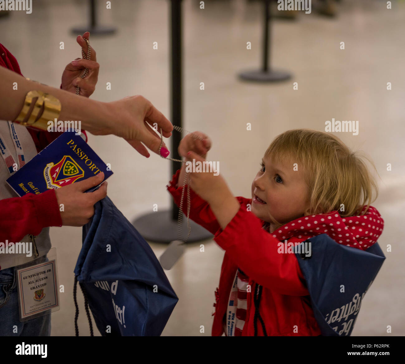 Un enfant reçoit des dog tags, un passeport, et un sac rempli de préparation avec d'autres articles le 4 avril 2016, à Mountain Home Air Force Base, Texas. Les goodies ont été donnés aux enfants qui ont traversé la ligne de déploiement simulée. (U.S. Air Force photo par Airman Malaisie Berry/libérés) Banque D'Images