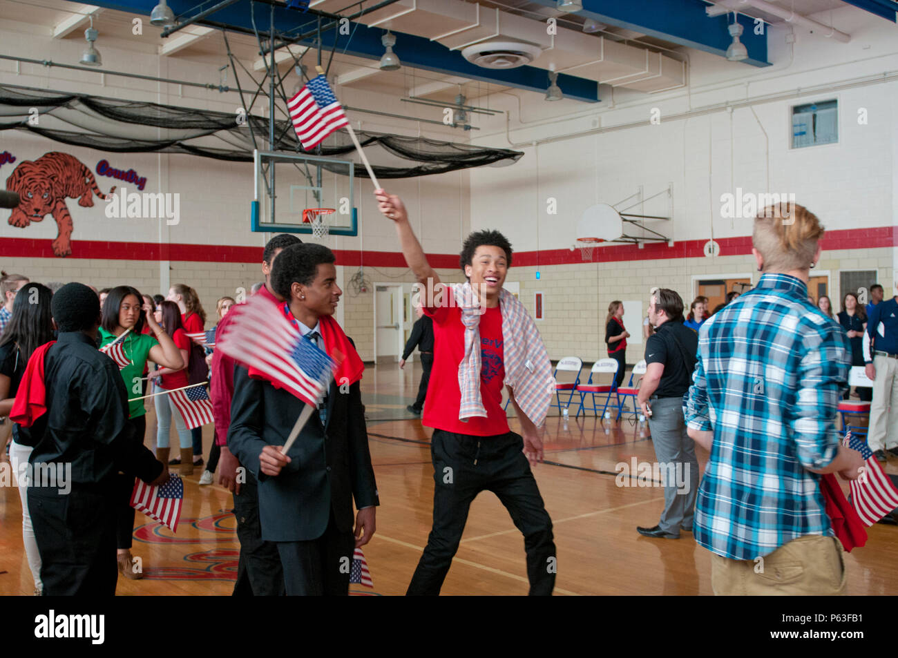 Les étudiants de l'École Zone McKeesport vague le drapeau américain lors d'une cérémonie pour le s.. Michelle Satterfield, avec le 14e Détachement de quartier-maître, à McKeesport, Pennsylvanie, le 25 avril 2016. Satterfield reçoit une maison construite par les étudiants de l'McKeesport Area High School et Stephen Siller Tunnel à la base de tous les tours du travail bénévole qu'elle a accompli au cours des dernières années. (U.S. Photo de l'armée par le sergent. Dalton Smith / relâché) Banque D'Images