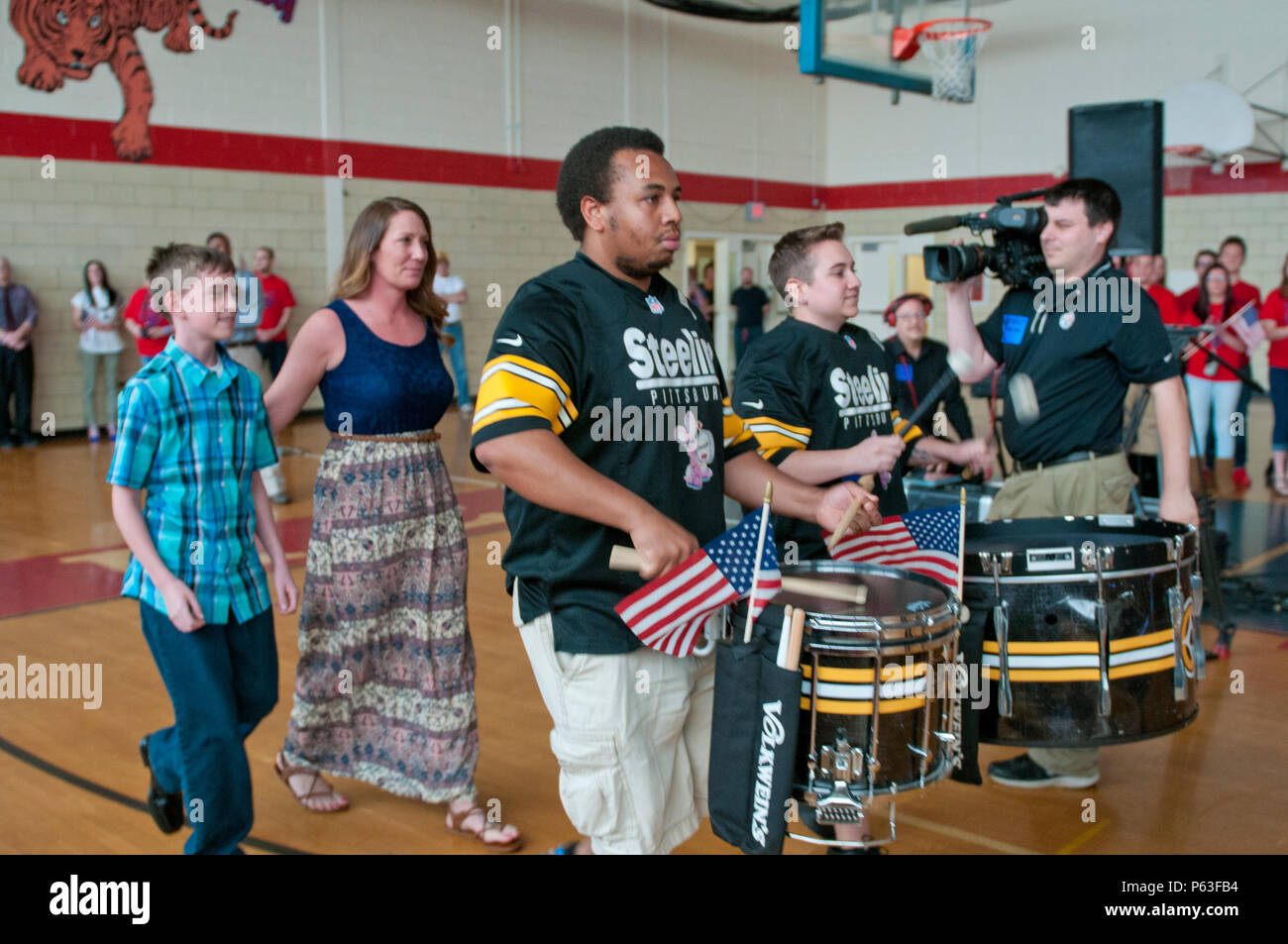 La Pittsburgh Steelers' Steeline ligne tambour apporter dans le s.. Michelle Satterfield et son fils, Hunter, lors d'une cérémonie pour Satterfield à McKeesport, Pennsylvanie, le 25 avril 2016. Satterfield reçoit une maison construite par les étudiants de l'McKeesport Area High School et Stephen Siller Tunnel à la base de tous les tours du travail bénévole qu'elle a accompli au cours des dernières années. (U.S. Photo de l'armée par le sergent. Dalton Smith / relâché) Banque D'Images