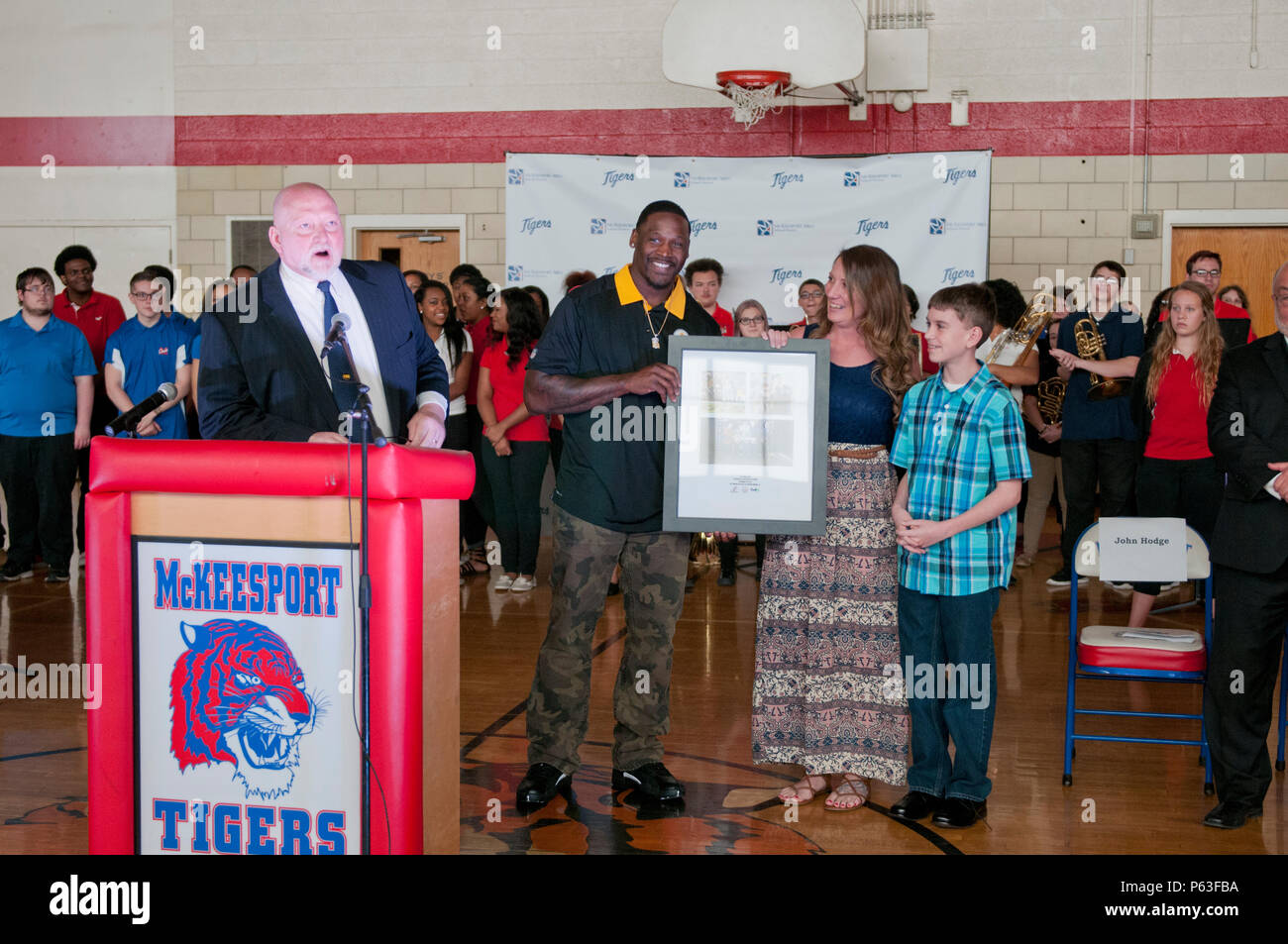 Arthur Moats, Pittsburgh Steelers linebacker, présente un collage de photos pour le s.. Michelle Satterfield, avec le 14e Détachement de quartier-maître, lors d'une cérémonie pour Satterfield à McKeesport, Pennsylvanie, le 25 avril 2016. Satterfield reçoit une maison construite par les étudiants de l'McKeesport Area High School et Stephen Siller Tunnel à la base de tous les tours du travail bénévole qu'elle a accompli au cours des dernières années. (U.S. Photo de l'armée par le sergent. Dalton Smith / relâché) Banque D'Images