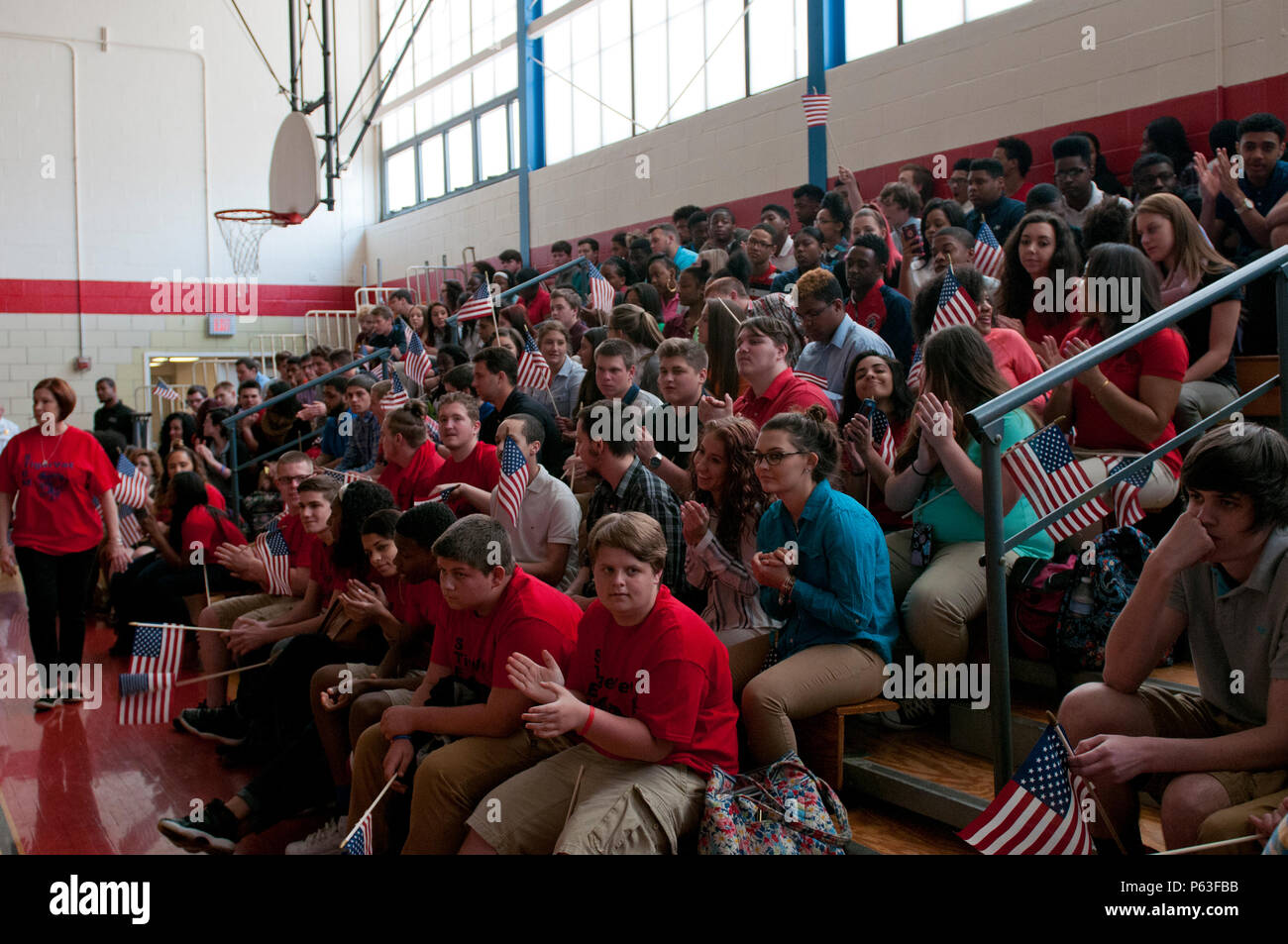 Les étudiants de l'École Zone McKeesport vague le drapeau américain lors d'une cérémonie pour le s.. Michelle Satterfield à McKeesport, Pennsylvanie, le 25 avril 2016. Satterfield reçoit une maison construite par les étudiants de l'McKeesport Area High School et Stephen Siller Tunnel à la base de tous les tours du travail bénévole qu'elle a accompli au cours des dernières années. (U.S. Photo de l'armée par le sergent. Dalton Smith / relâché) Banque D'Images