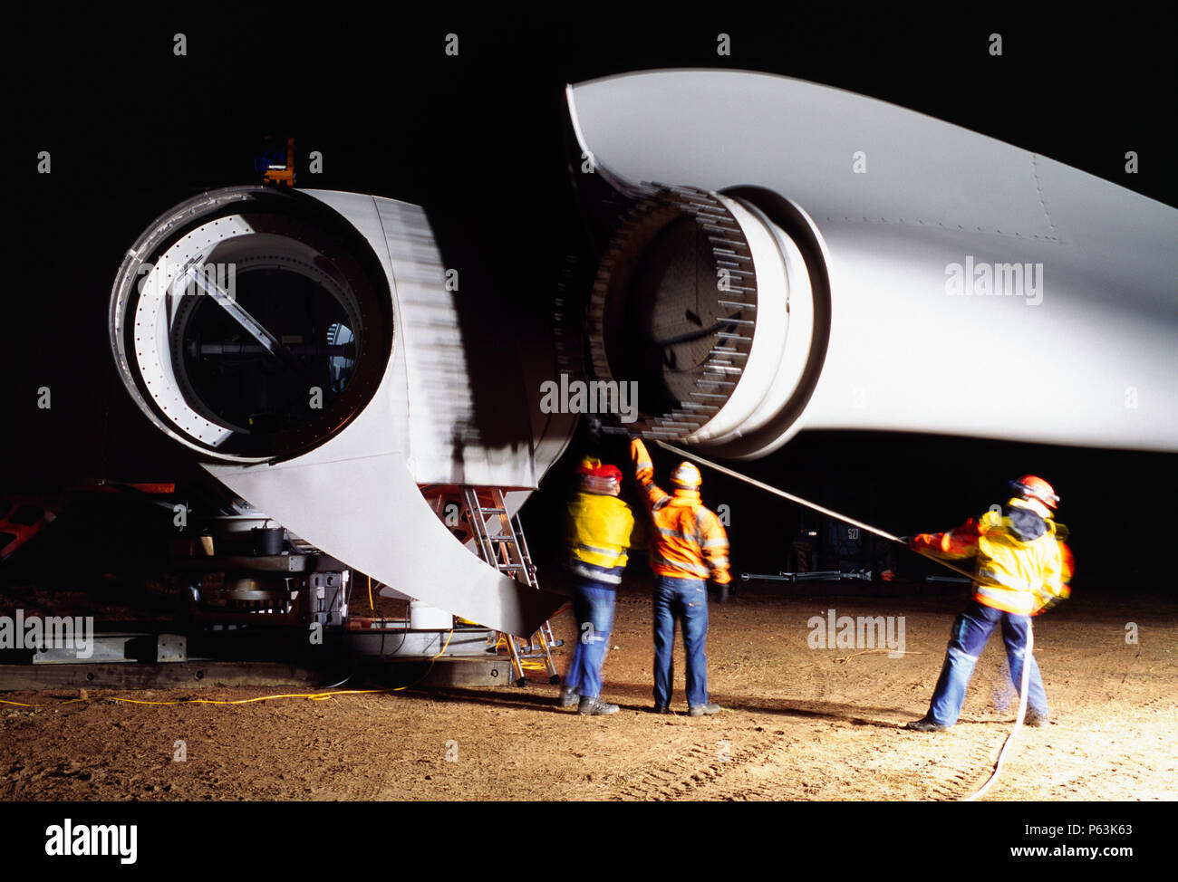 Long expopsure tourné de nuit, puisque trois travailleurs un guide lame dans le moyeu d'une éolienne Enercon géant. Worksop Royaume-uni. Décembre 2008. Banque D'Images