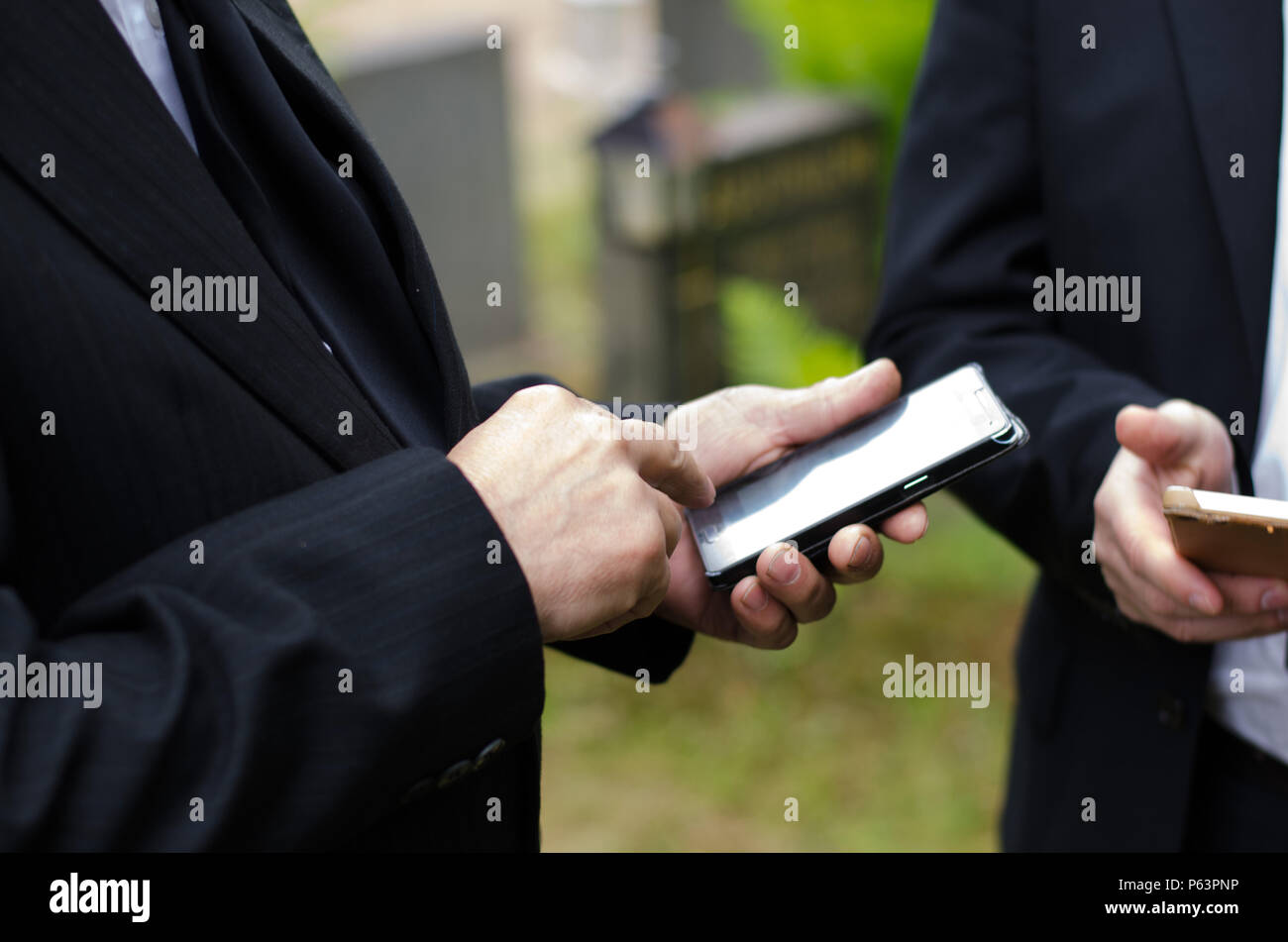 Un homme âgé en costume sombre en utilisant un téléphone mobile Banque D'Images