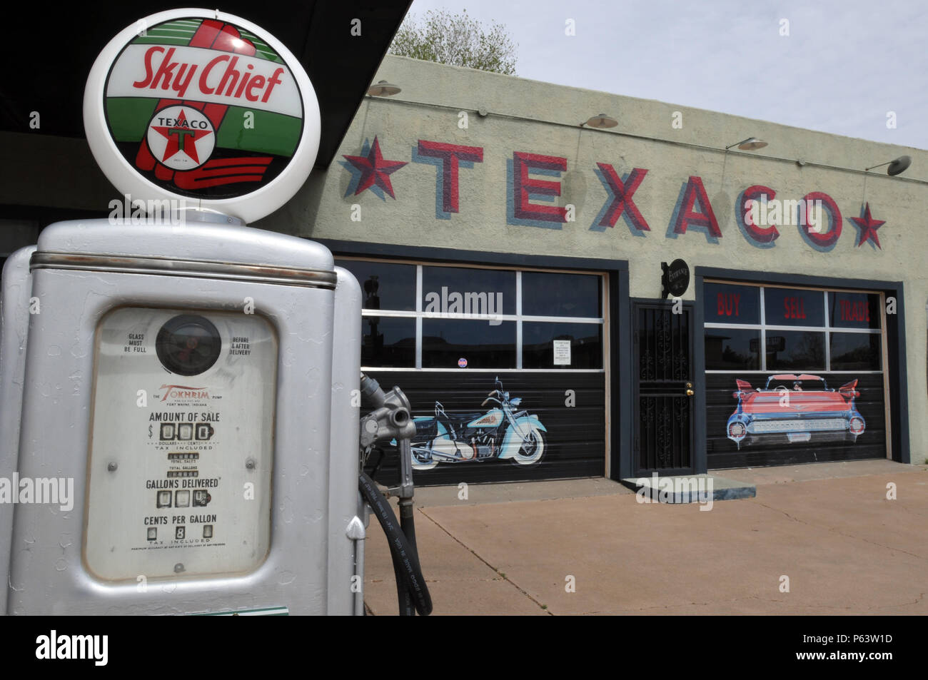 Une pompe à gaz vintage à un ancien garage sporting une murale de Texaco, partie d'un projet de restauration et d'art public dans la ville de Tucumcari Route 66, NM. Banque D'Images