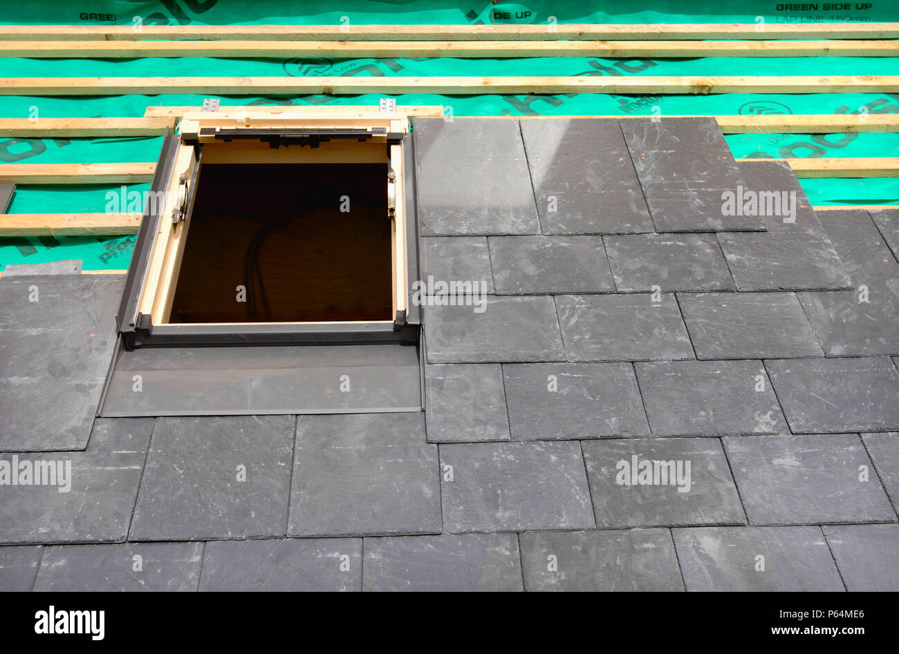 La pose d'un velux sur une toiture en ardoise en construction montrant la  toiture respirant l'impression avec des matraques en bois Photo Stock -  Alamy