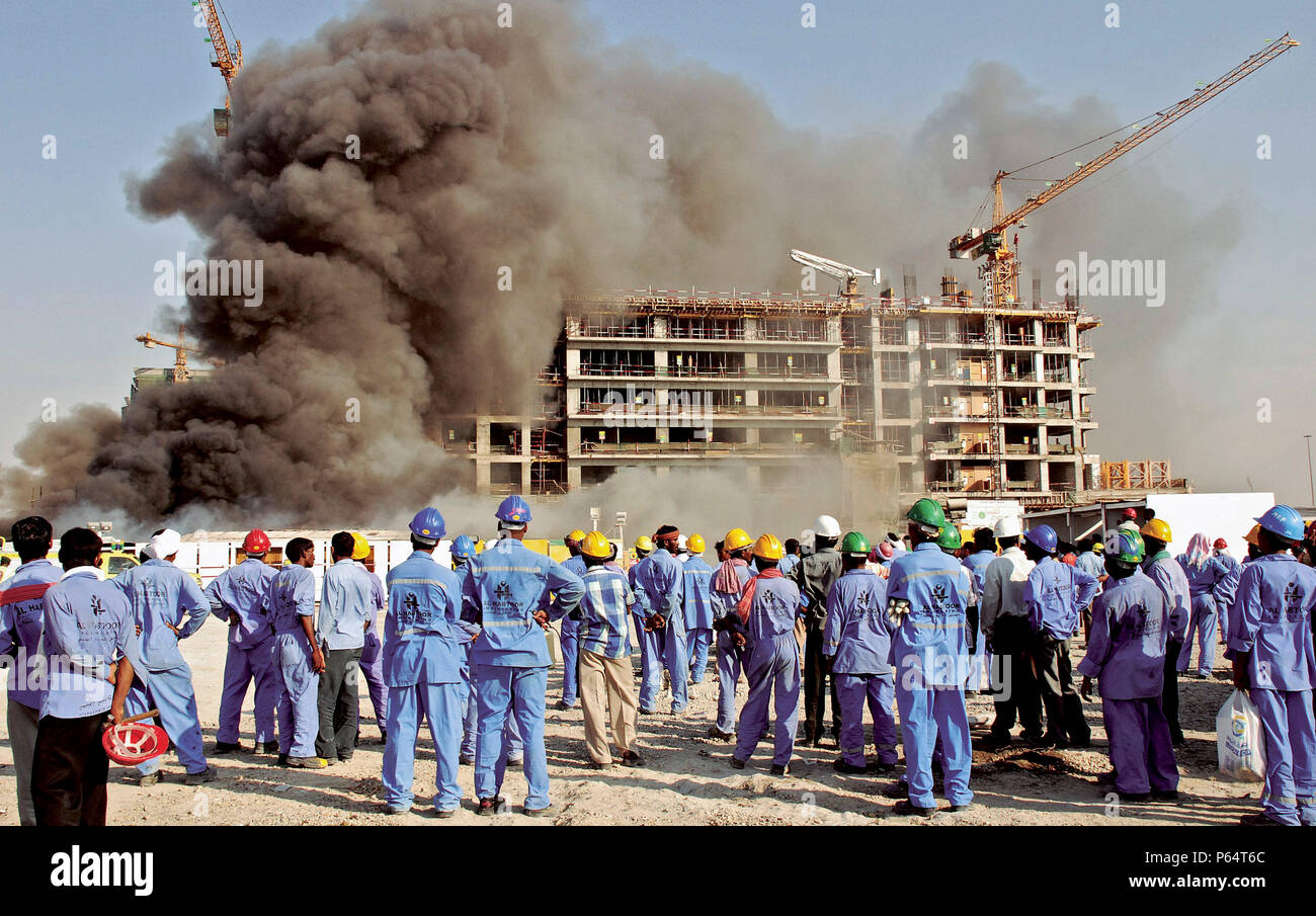 Al Mumzar zone industrielle. Regarder leurs ouvriers en construction bâtiment frappé par le feu, Dubaï, Émirats arabes unis, le 22 octobre 2006. Banque D'Images