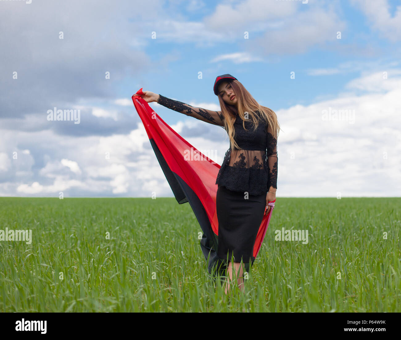 Belle jeune fille ukrainienne avec une excellente figure dans une robe courte noire détient un drapeau noir rouge national ukrainien Banque D'Images