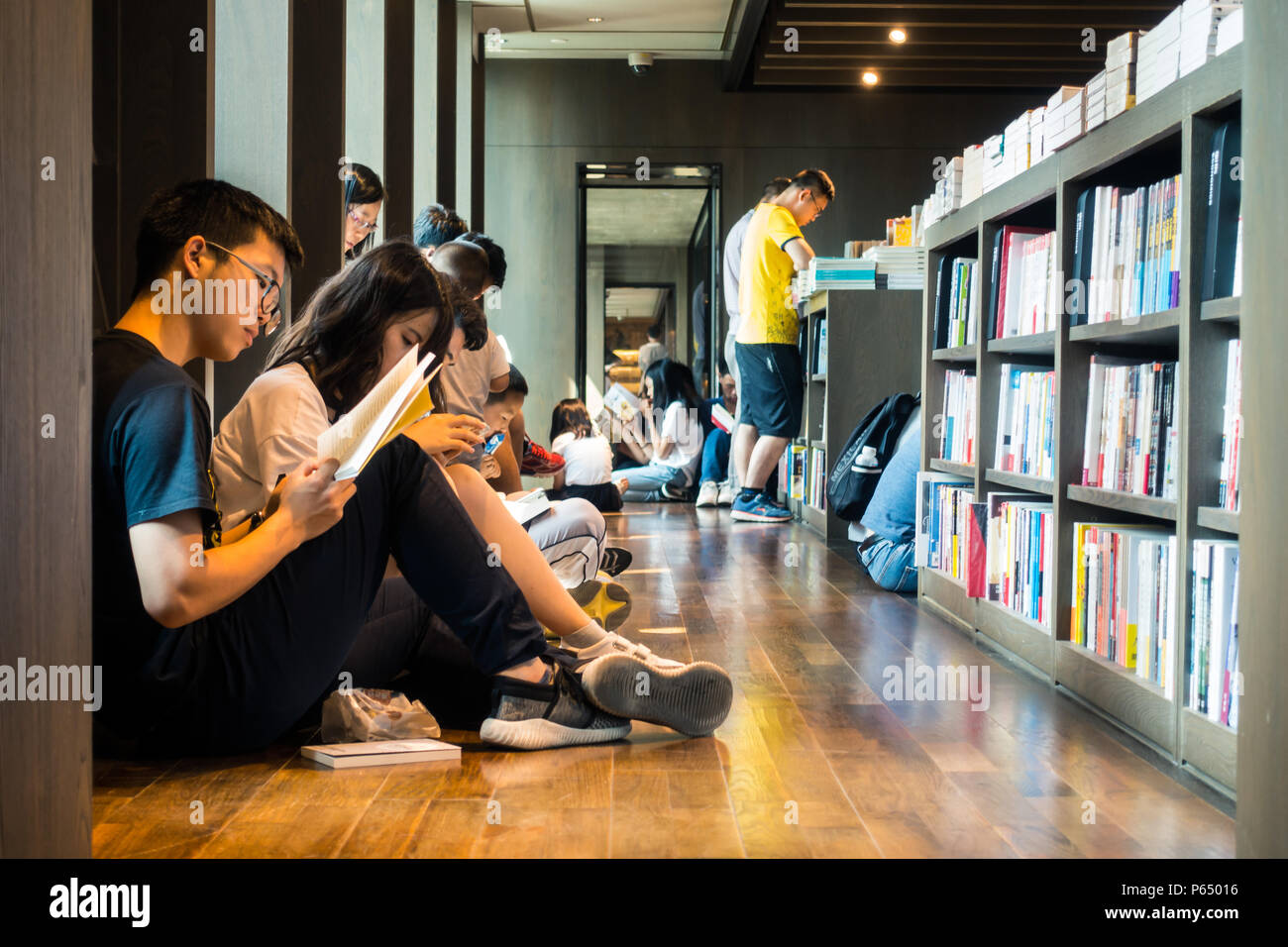 Chine-juin,2018:Chinois assis sur le plancher la lecture de livres Banque D'Images