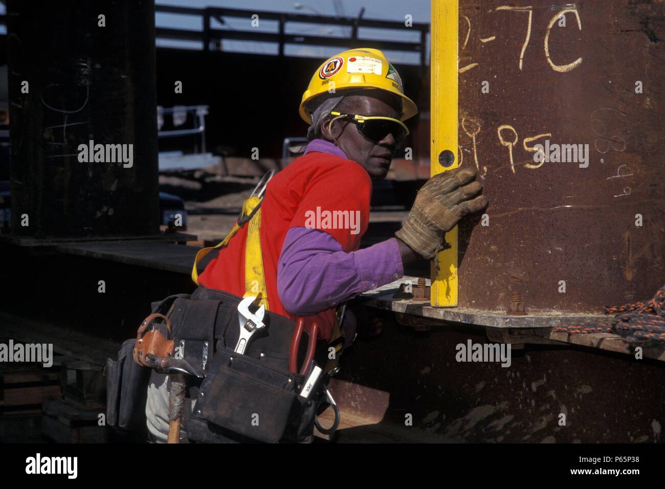 Female construction worker using level sur cintre du pont Banque D'Images