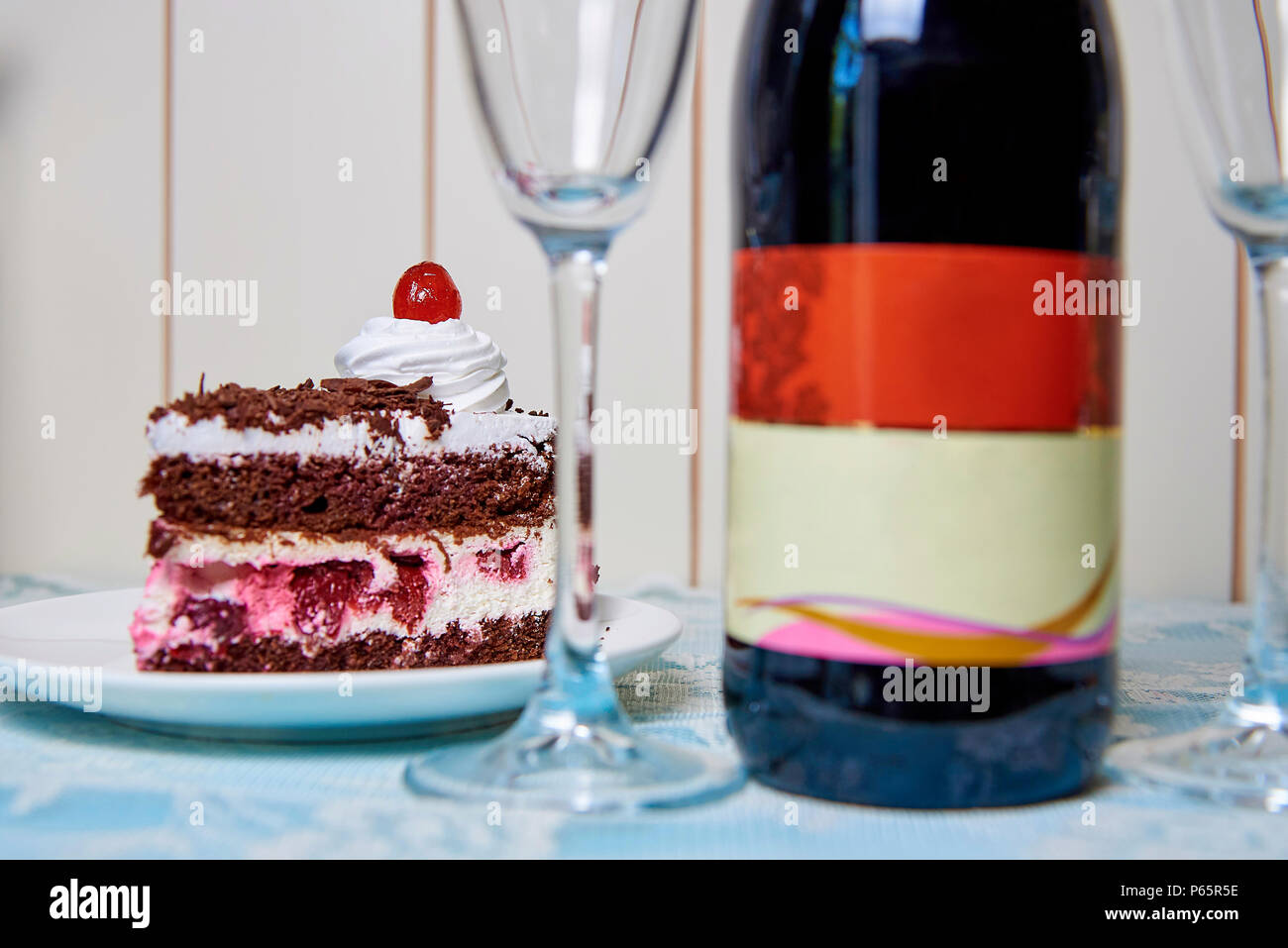 Gateau Au Chocolat Avec Creme Et De Cerisier Pres D Une Bouteille De Vin Trouble Et Lunettes Photo Stock Alamy