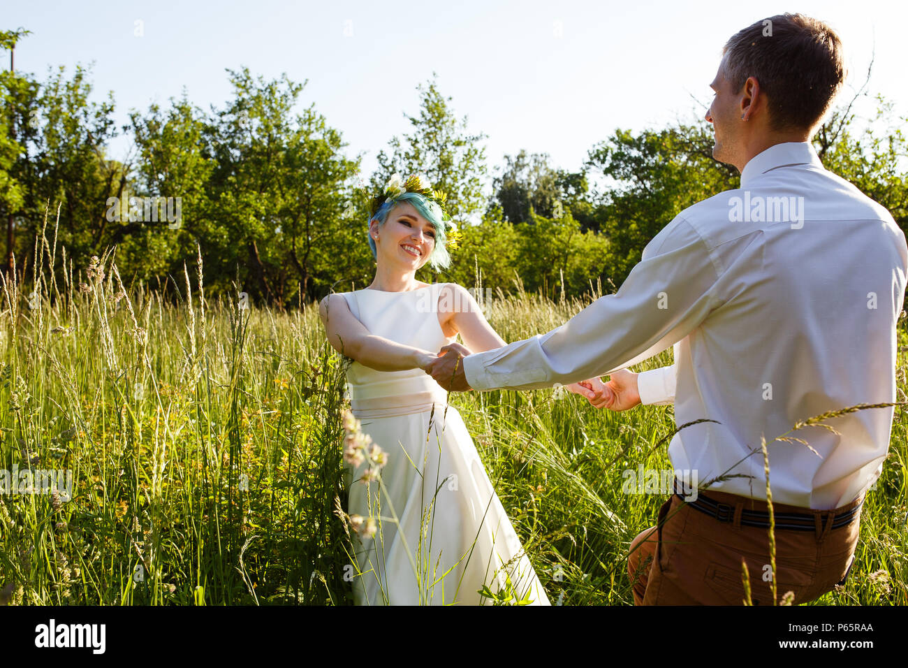 Jeune couple de profiter de moments romantiques à l'extérieur sur une prairie d'été. La fille a des cheveux bleus. Banque D'Images