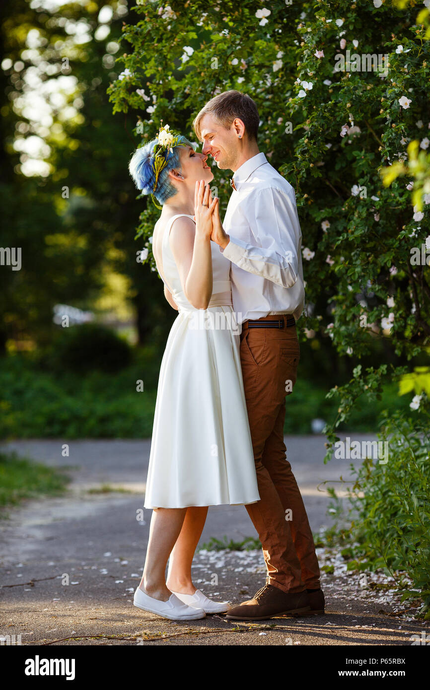 Jeune couple de profiter de moments romantiques à l'extérieur sur une prairie d'été. La fille a des cheveux bleus. Banque D'Images