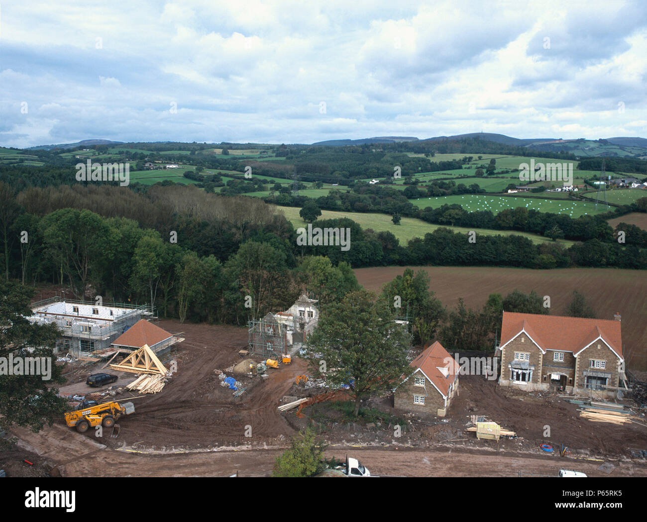 La construction de nouvelles maisons individuelles avec conversion d'étable pour chambre à proximité. Le Pays de Galles. Banque D'Images