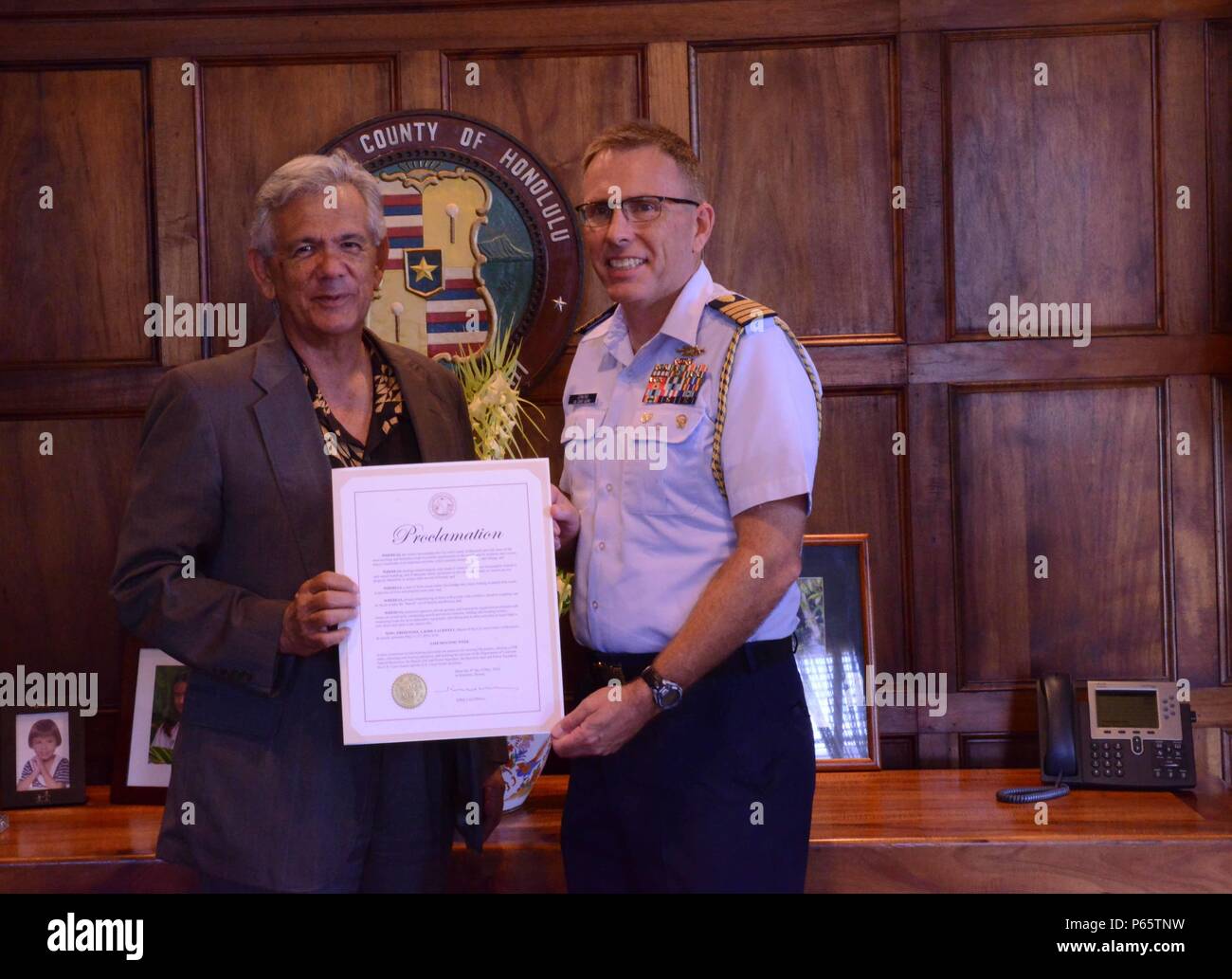 Le Capitaine James Jenkins, chef d'état-major de la Garde côtière 14ème arrondissement, pose avec Ray bientôt, le chef de cabinet pour le maire d'Honolulu Kirk Caldwell, après avoir signé une proclamation de la Semaine nationale de la sécurité nautique à Honolulu Hale, le 9 mai 2016. La proclamation reconnaît l'enjeu permanent de la sécurité nautique. La Semaine nationale de la sécurité nautique se déroulera du 21 au 27 mai et est une initiative annuelle parrainée par la Garde côtière et de la Garde côtière auxiliaire canadienne de sensibilisation et d'encourager la sécurité nautique. (U.S. Photos de la Garde côtière par Seaman Jack Mayers/libérés) Banque D'Images