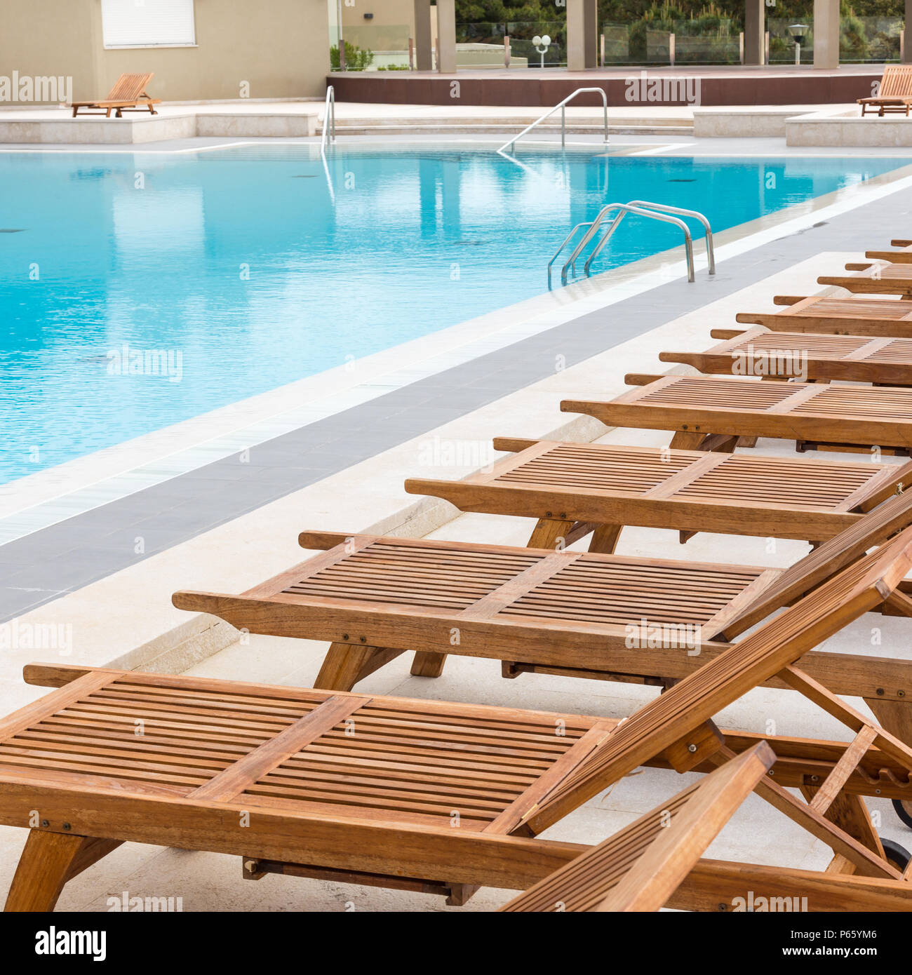 Piscine De luxe avec des chaises longues en bois. Banque D'Images