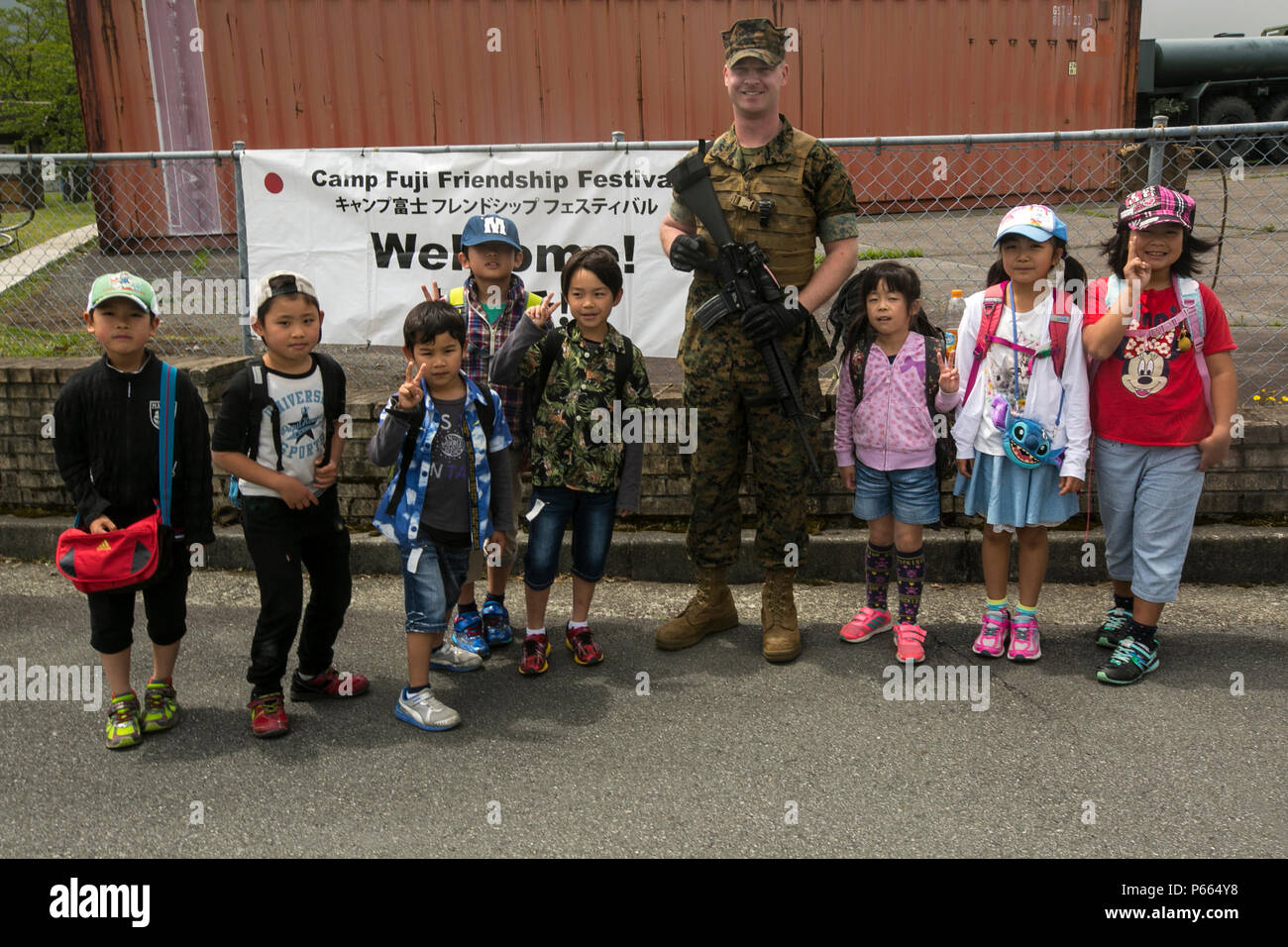 Lance le Cpl. Mason Jones pose avec les enfants en dehors de la Fuji Festival d'amitié le 7 mai à bord du centre de formation interarmes Fuji. Le festival inclus jeux et divertissements pour tous les âges, tels que maisons de rebond, la peinture du visage et des concerts d'artistes locaux et la 7ème Flotte américaine du groupe Orient Express. Le festival a également eu de nombreuses affiche de systèmes d'armes ainsi que des avions et des véhicules. Parmi eux se trouvaient des réservoirs japonais, un Black Hawk UH60 et le MV-22B Balbuzard. Banque D'Images