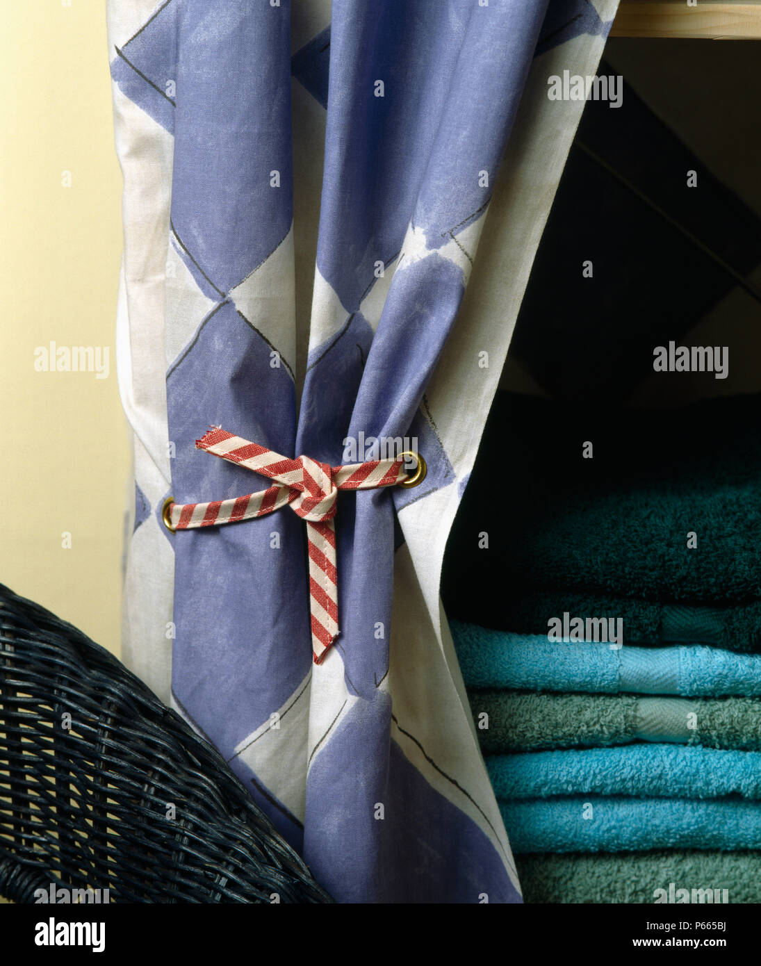 Close-up of Hand painted blue +blanc diamant-rideau à motifs sur étagère avec pile de serviettes Banque D'Images