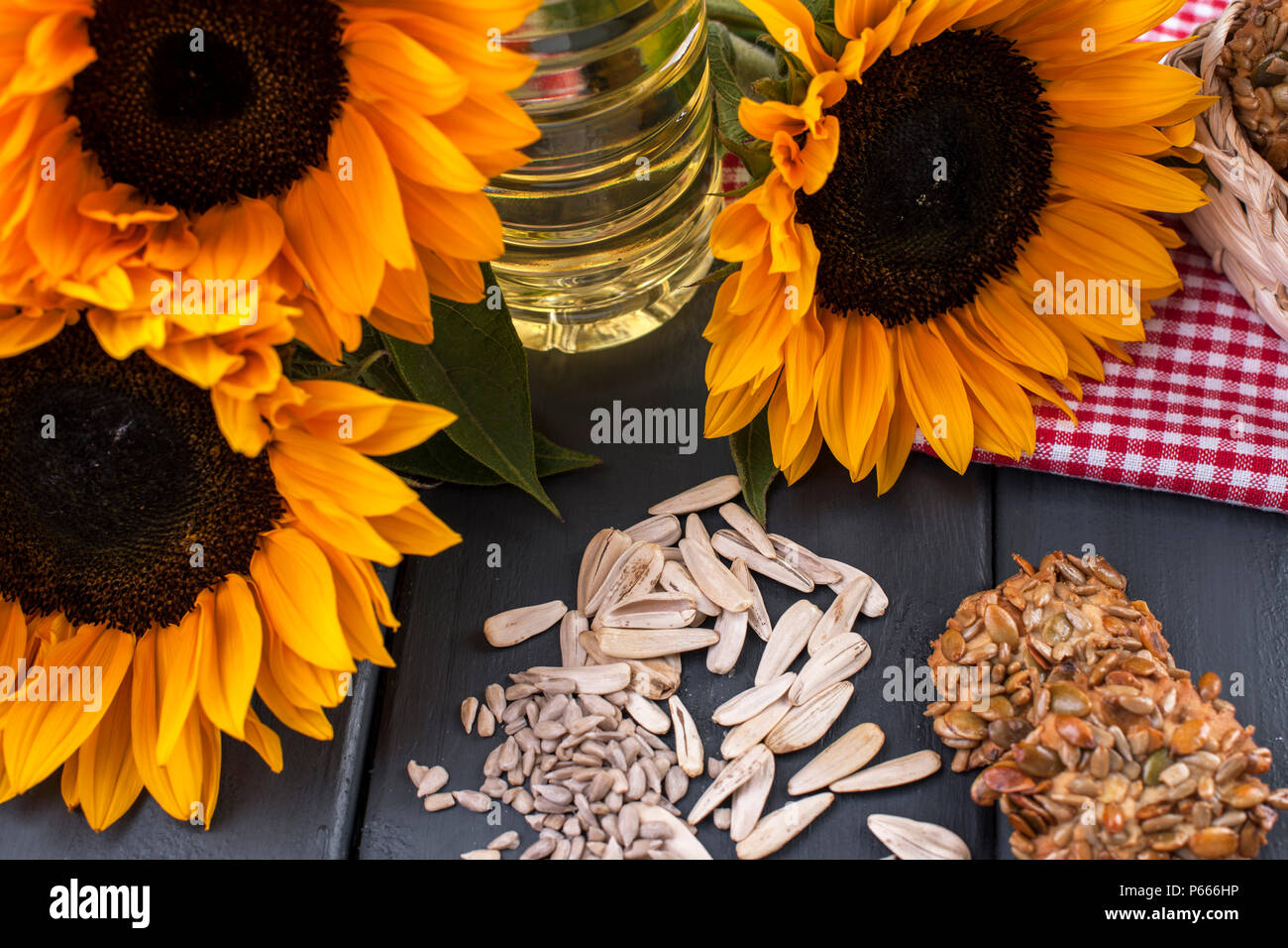 Dodsolnechnoe d'huile dans la bouteille, un bouquet de tournesols fleurs, sur un arrière-plan terned et graines dispersées. Produit naturel, style rustique. Copy space Banque D'Images
